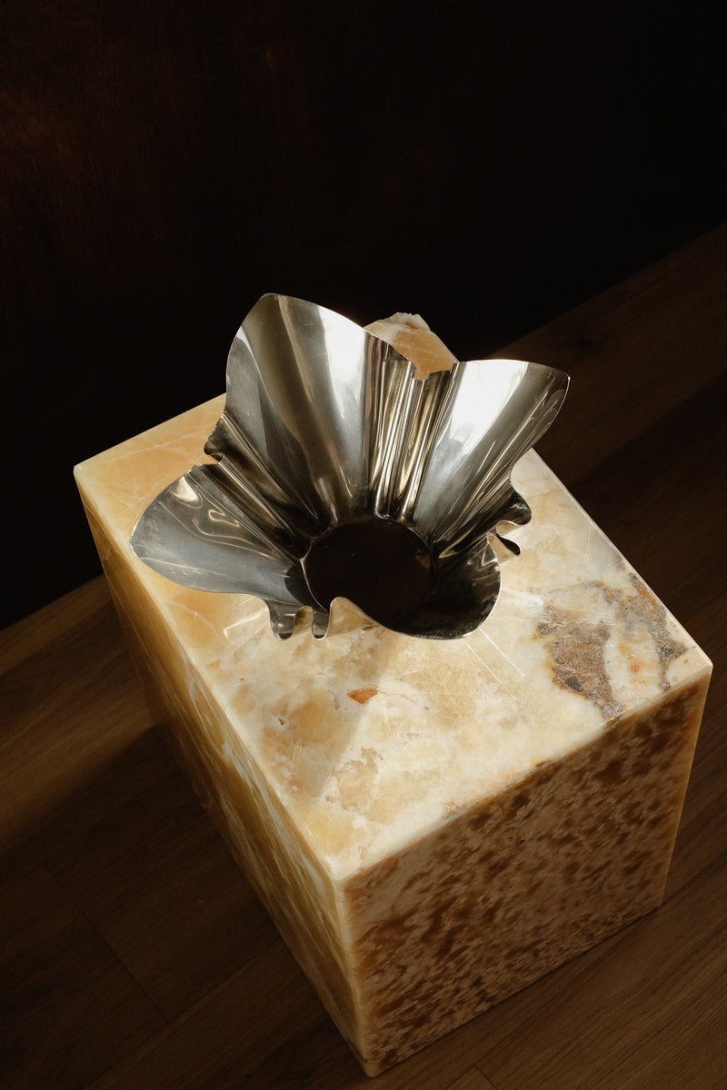 Folded Chrome Bowl — top view on marble pedestal