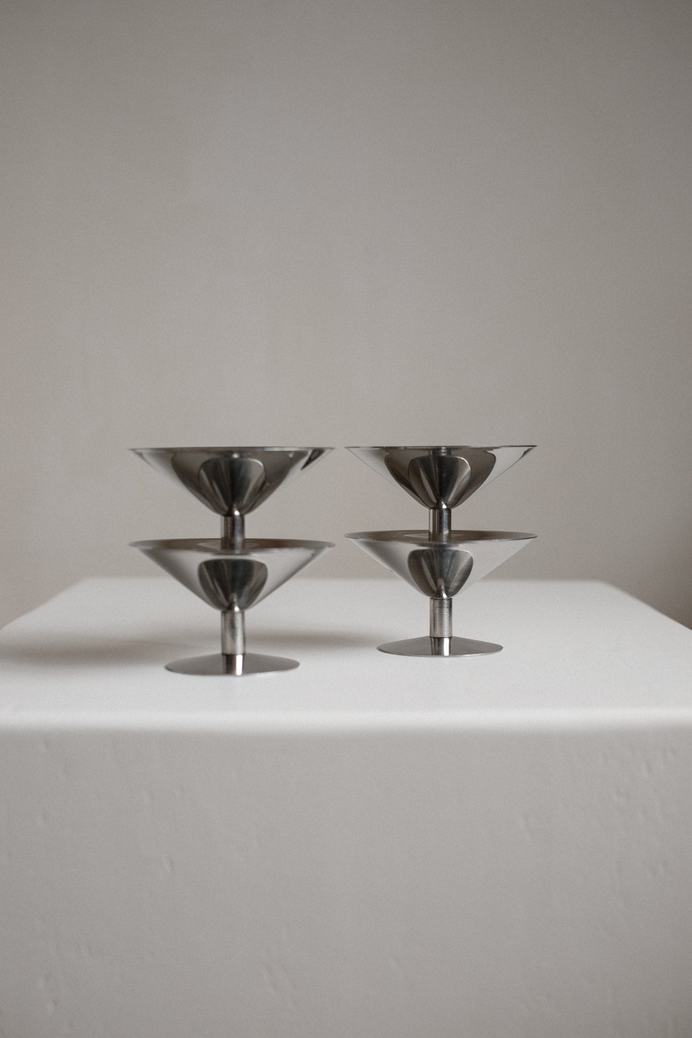 Set of Four Ice Coupes — close-up of polished metal surface on white pedestal
