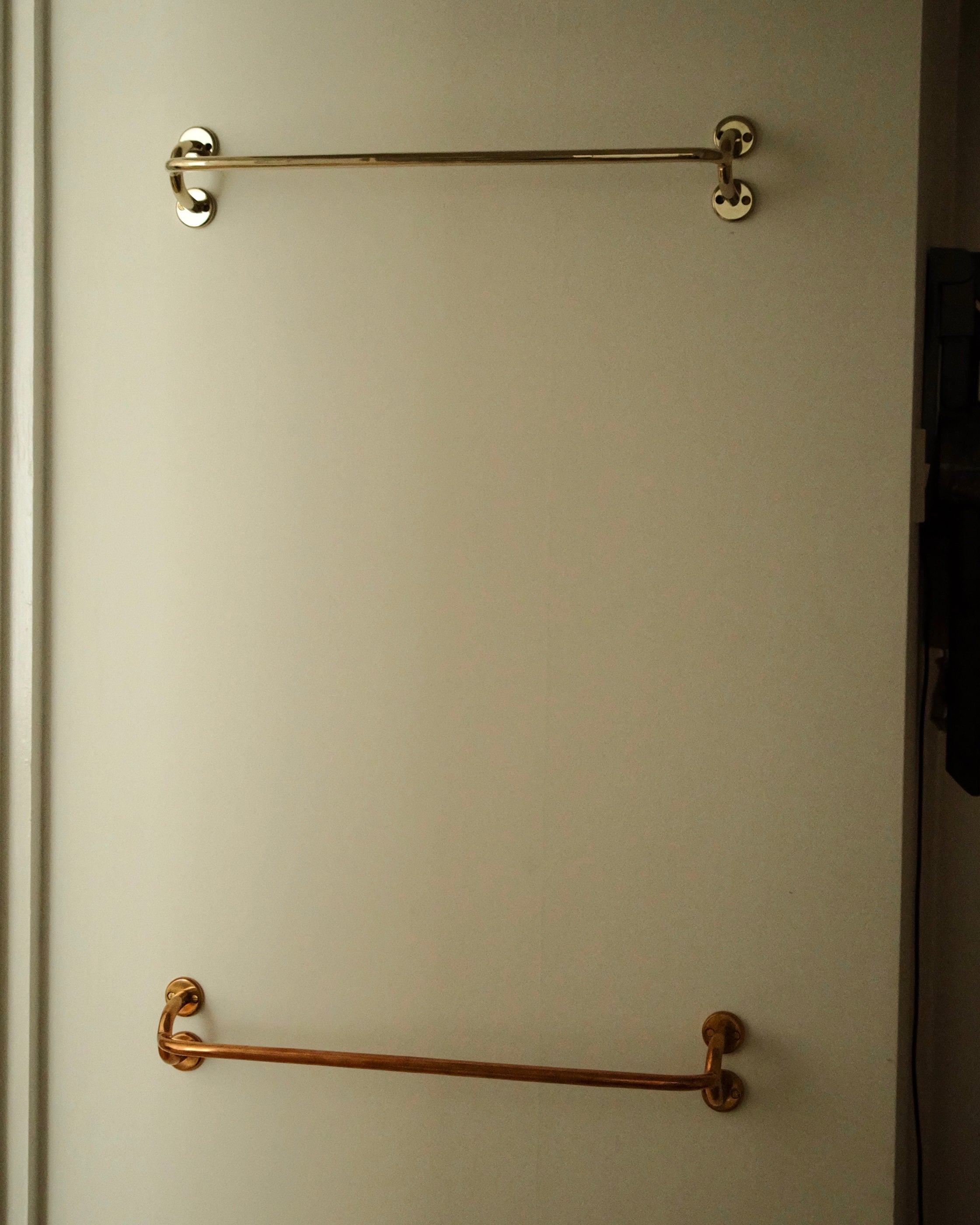 FAUNA Towel Bar (2 sizes) — top view of brass bars on door