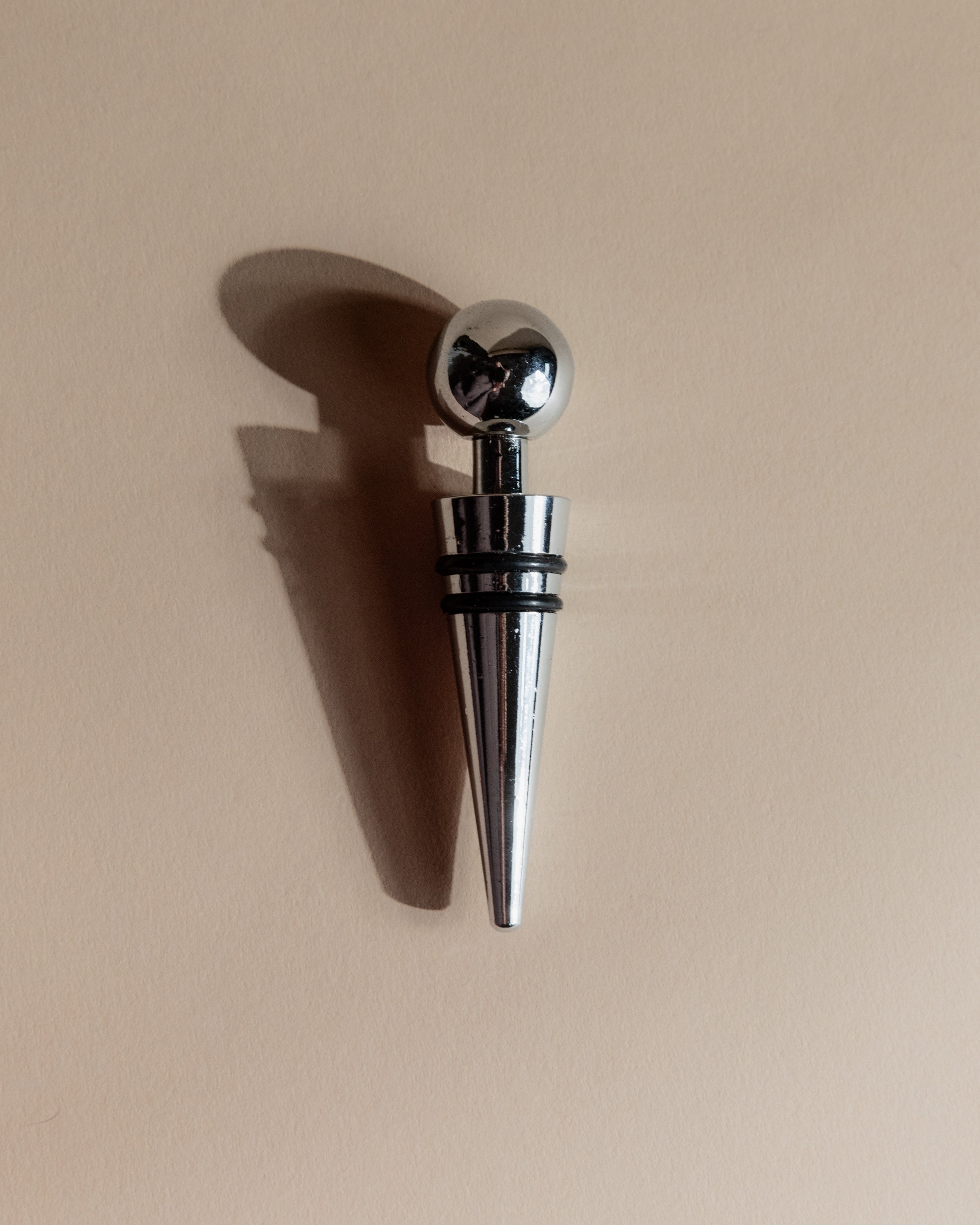 Vintage 1980s Bottle Stoppers Set of 2, Metal Geometric Conical Design Italy — top view of polished metal stopper with ball f