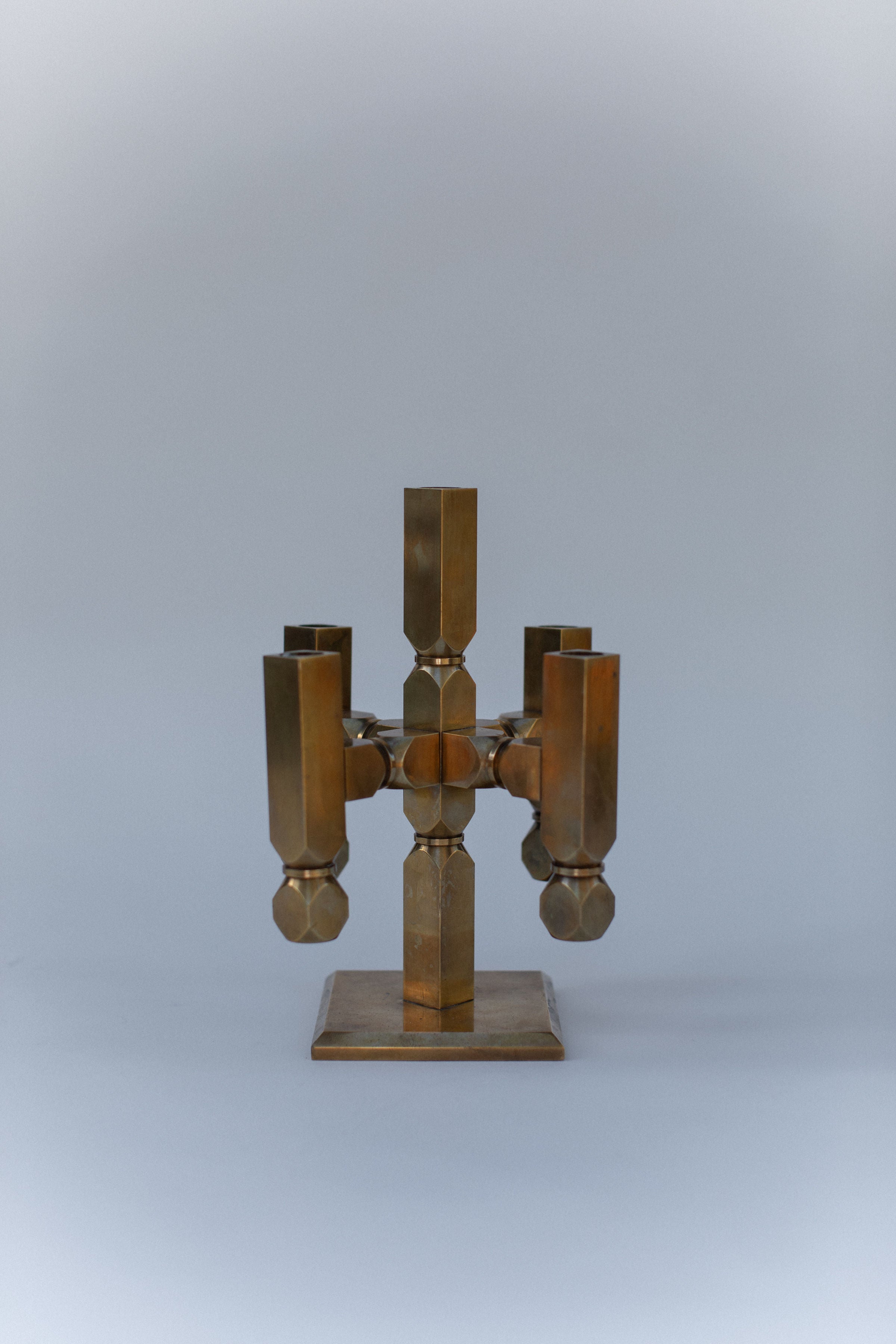 Brutalist brass candelabra with geometric cylindrical arms, front view