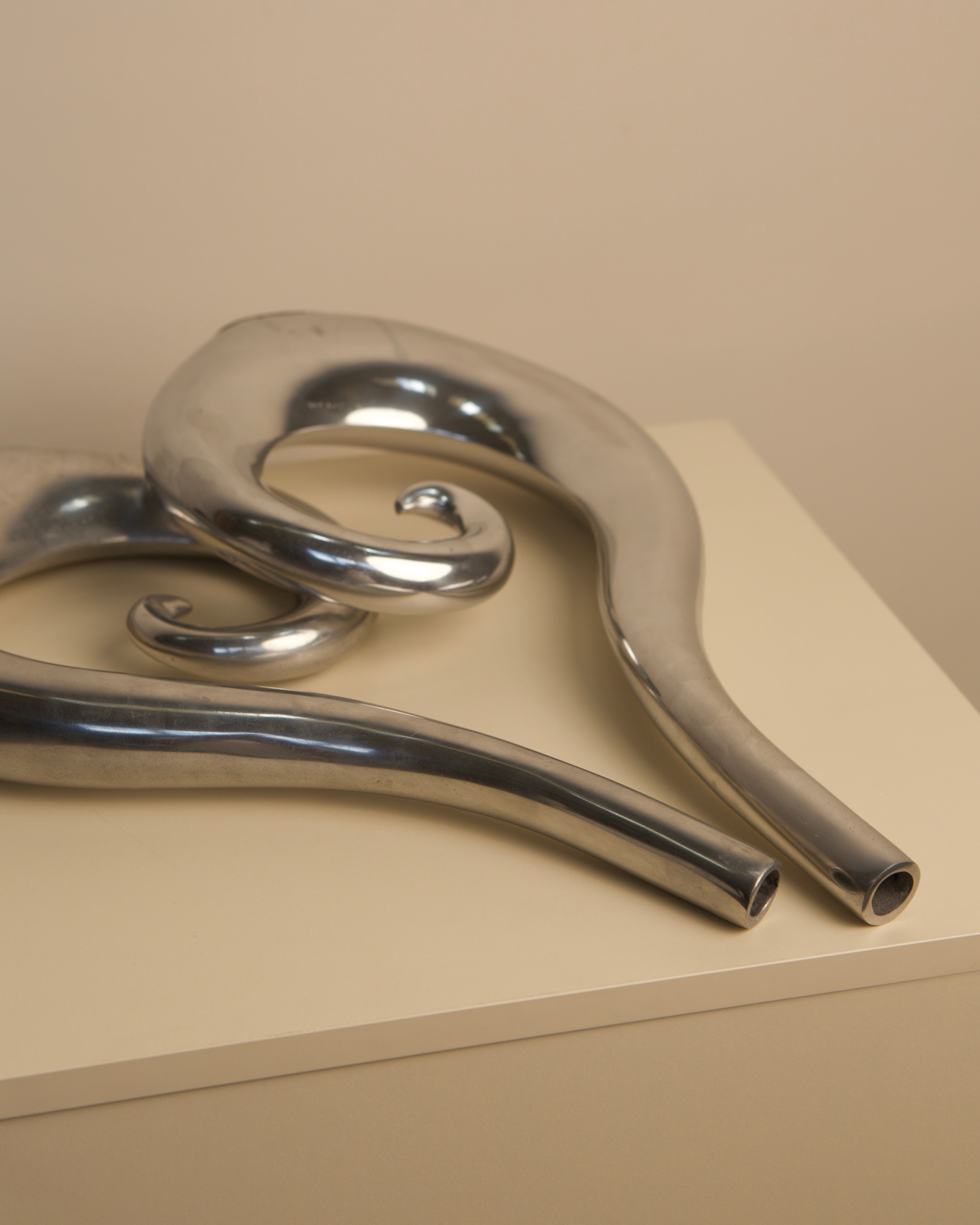 Close-up detail of curved aluminum tubes forming Italian 1980s vases