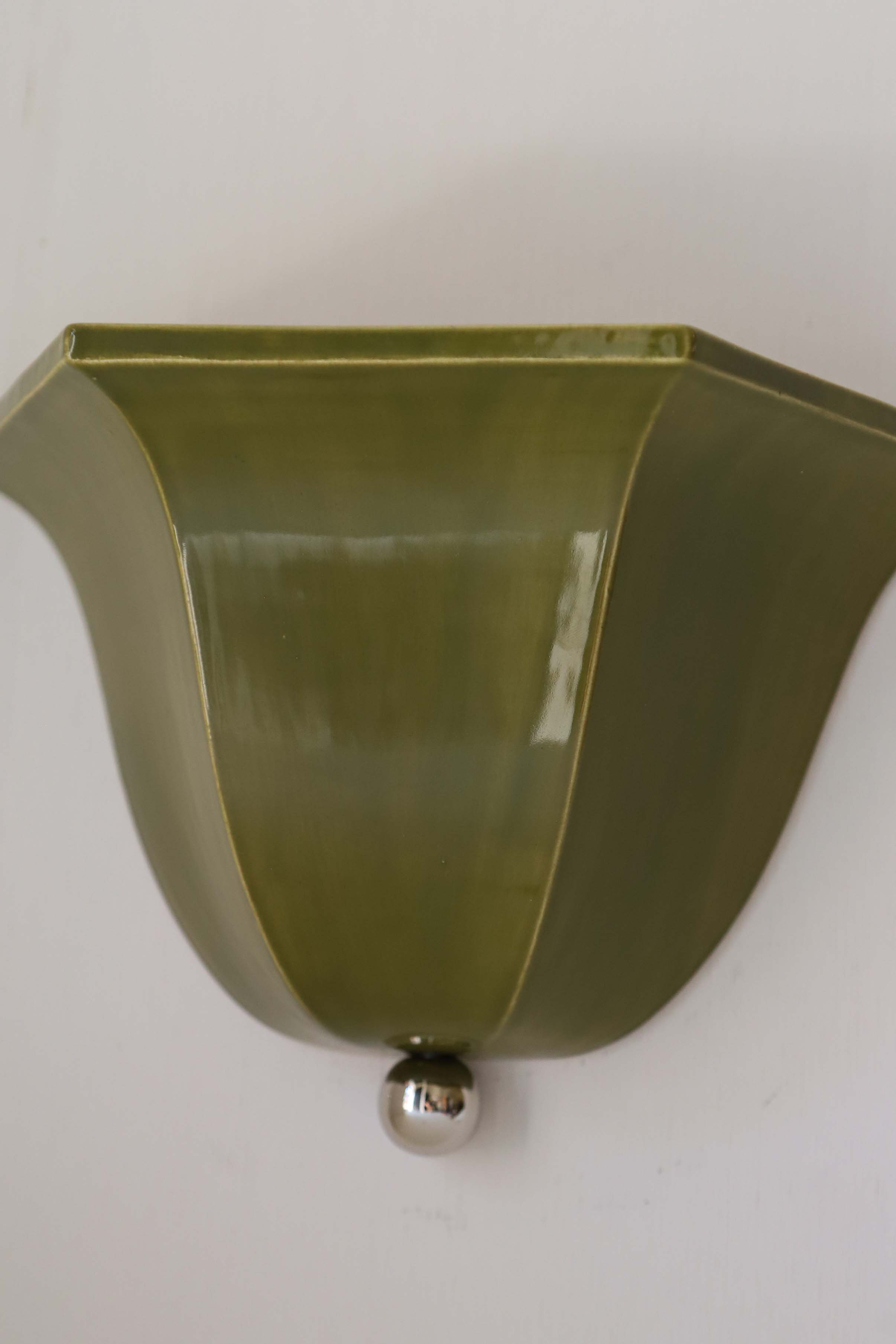 Olive green ceramic Maeve wall sconce with chrome mounting detail