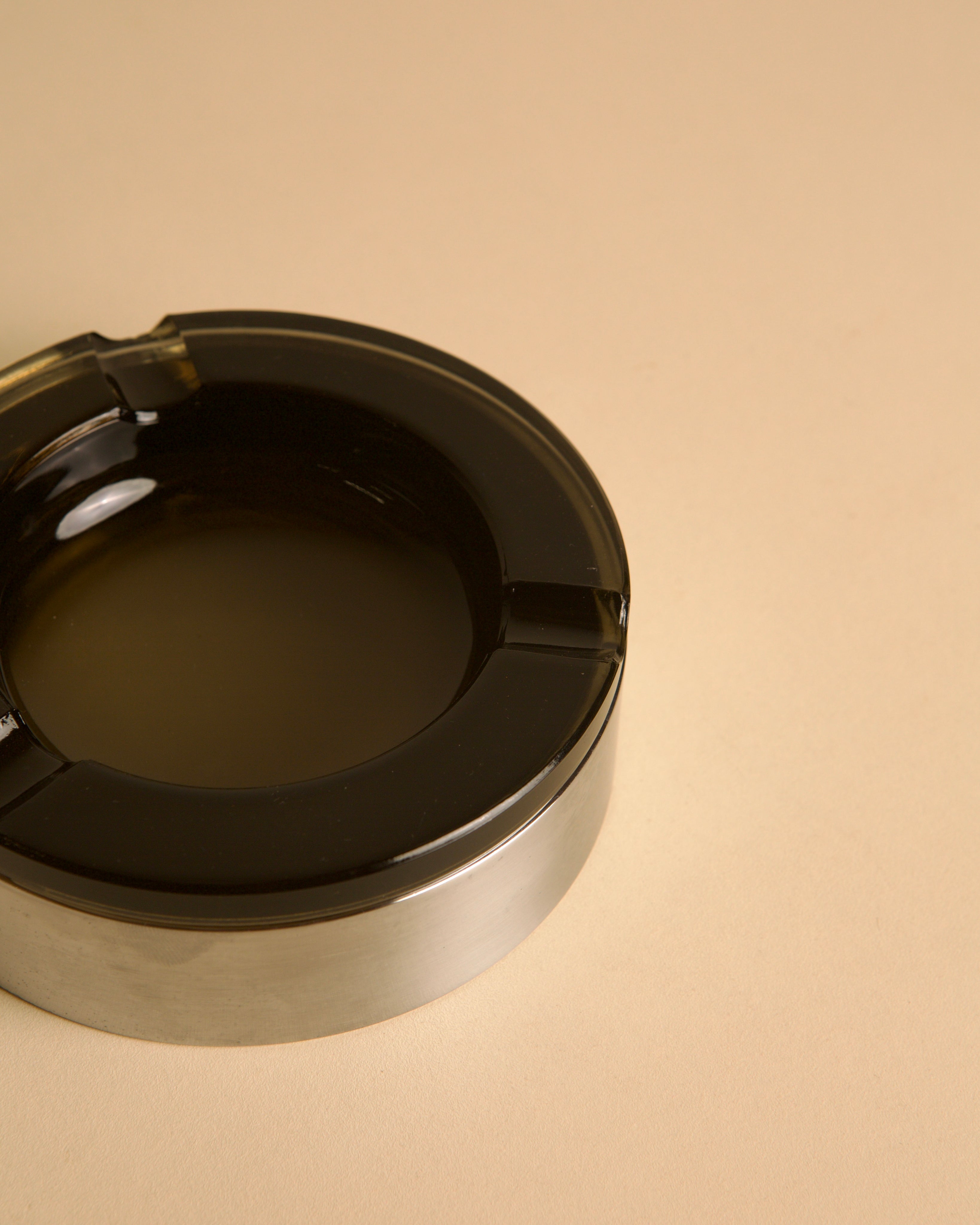Italian circular metal and amber glass ashtray, 1970s — side angle