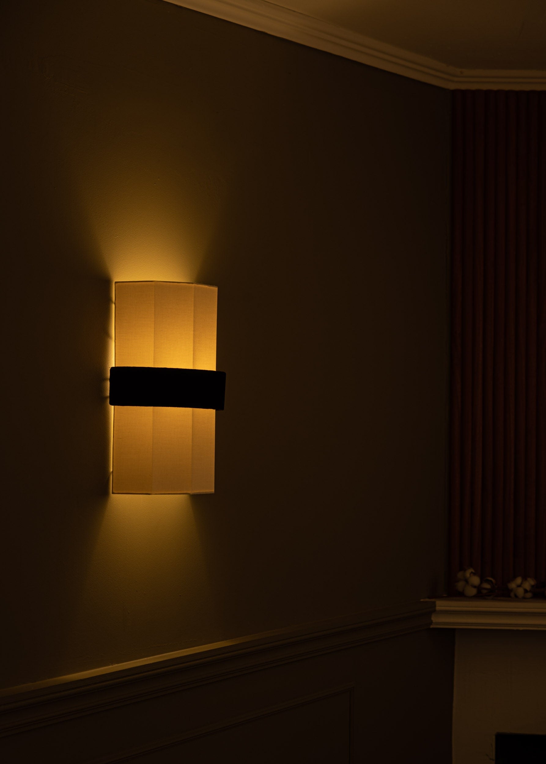 Modern black velvet wall sconce with warm ambient lighting