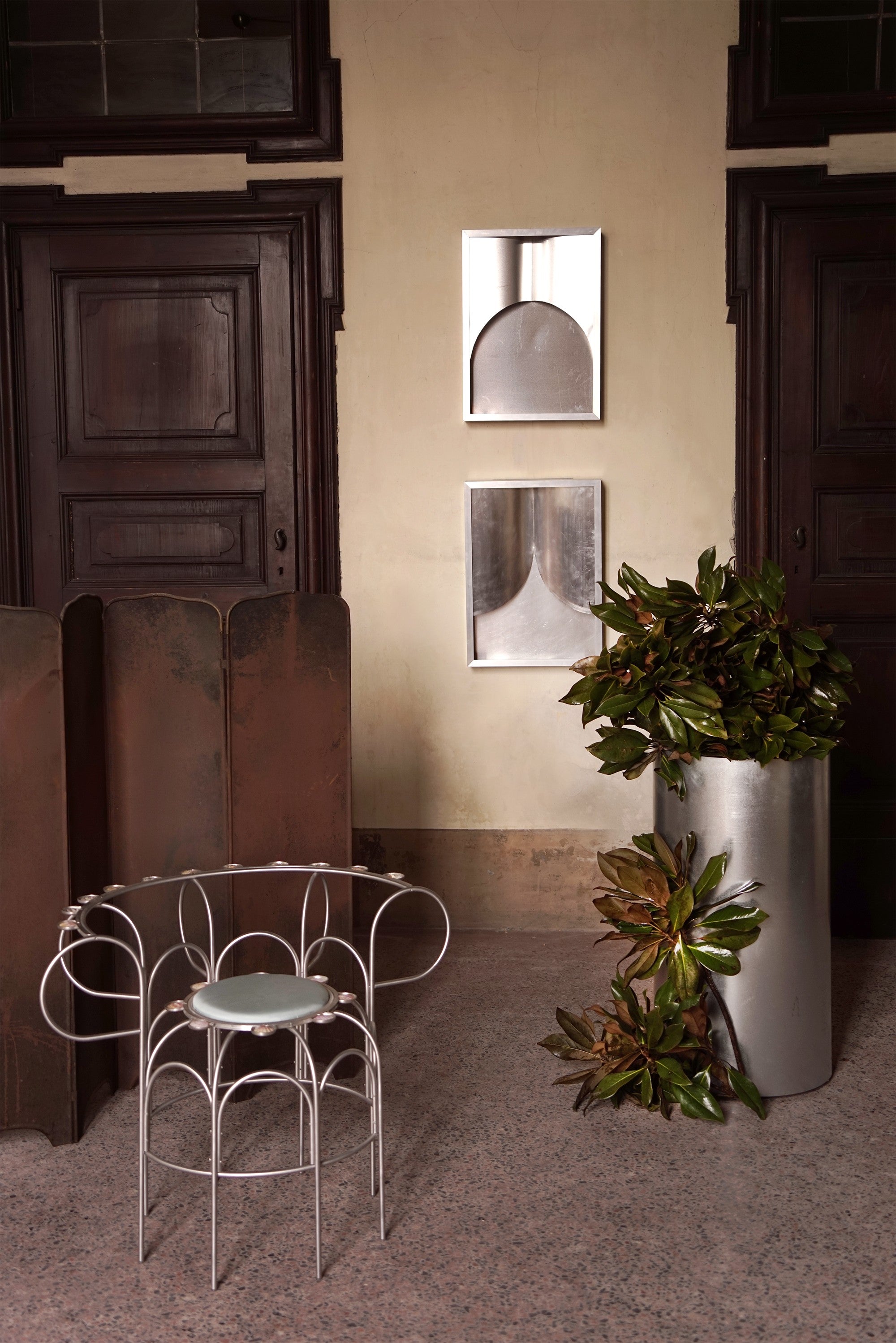 The Armchair With Shells — close-up of white metal frame in hallway