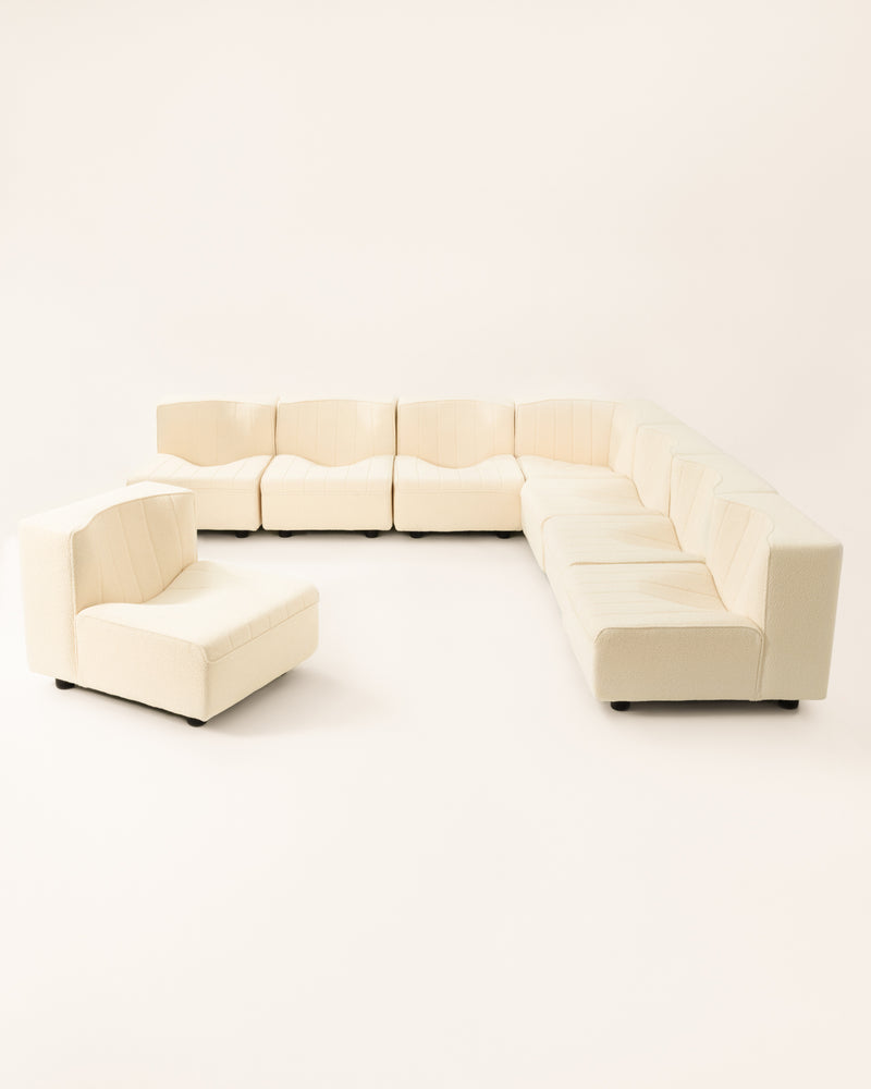 Cream modular sofa sections arranged in U-shape configuration