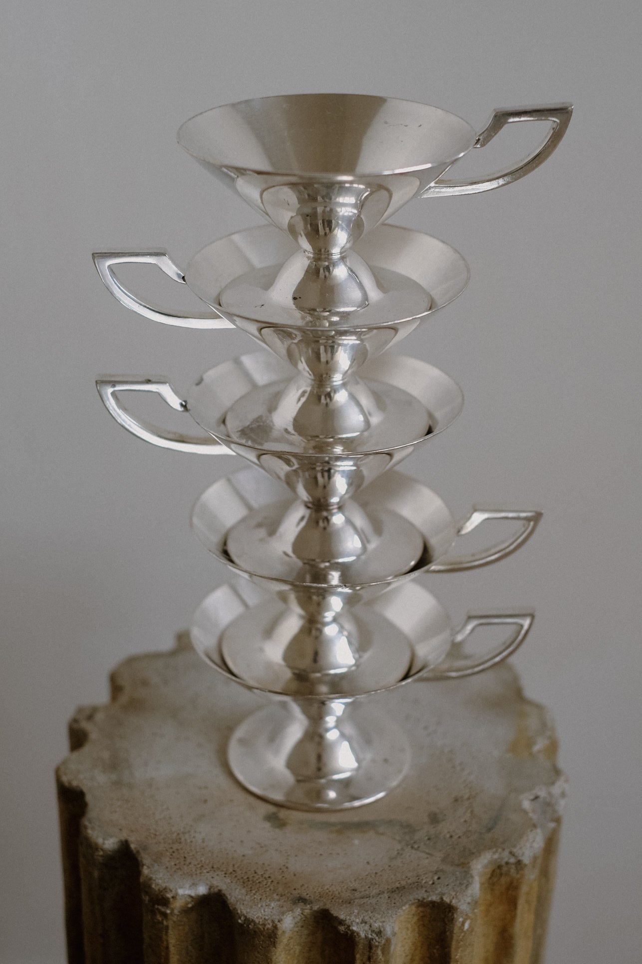Set of Serving Cups in Silver — stacked view on textured pedestal