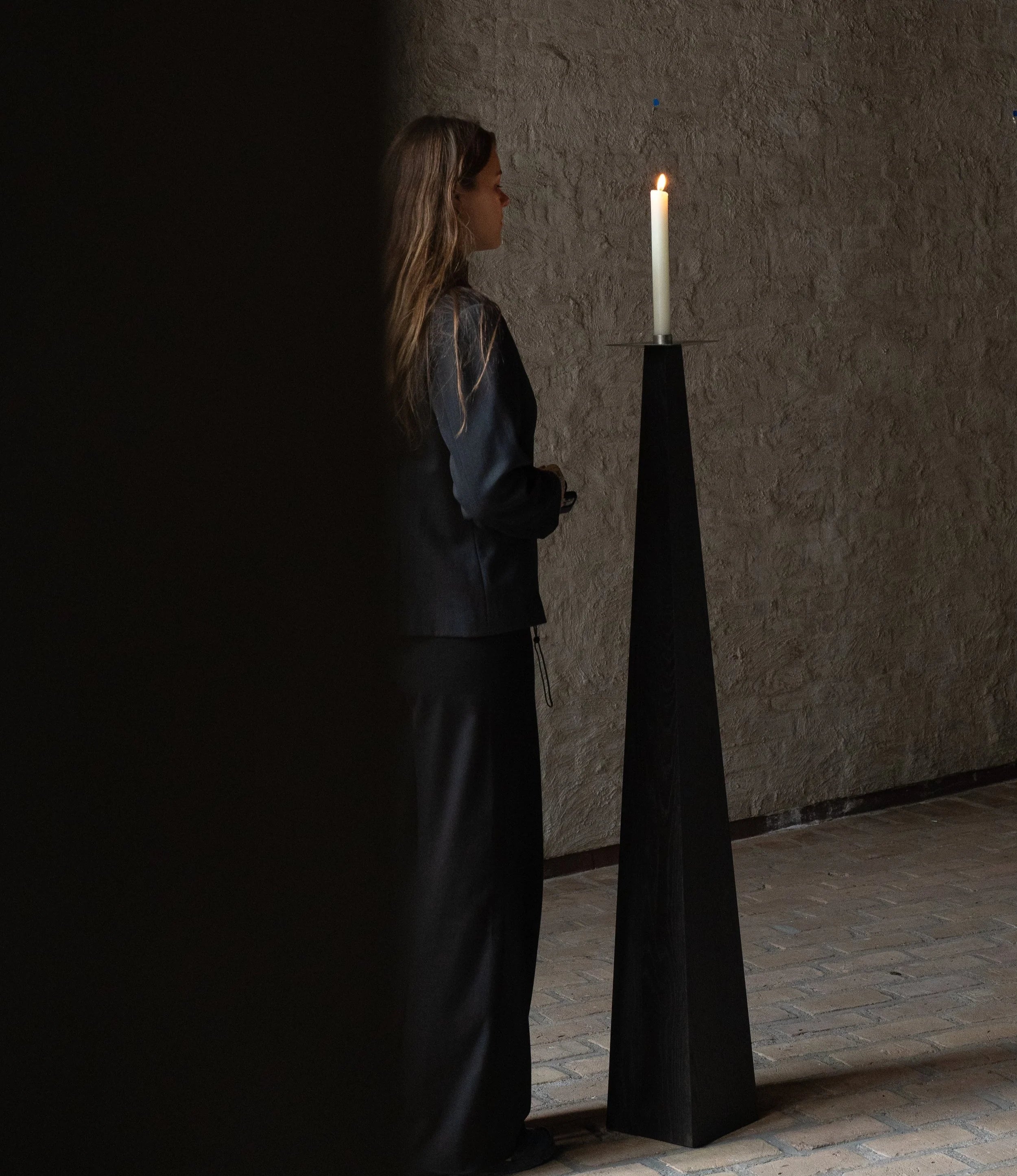 Taes Candle Holder — tall black wooden holder with lit candle