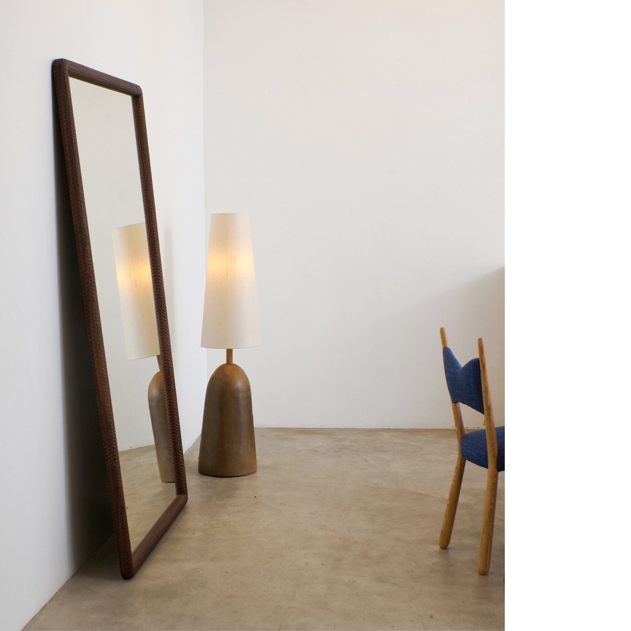 Amarante Mirror X Large — angled view against light wall with lamp