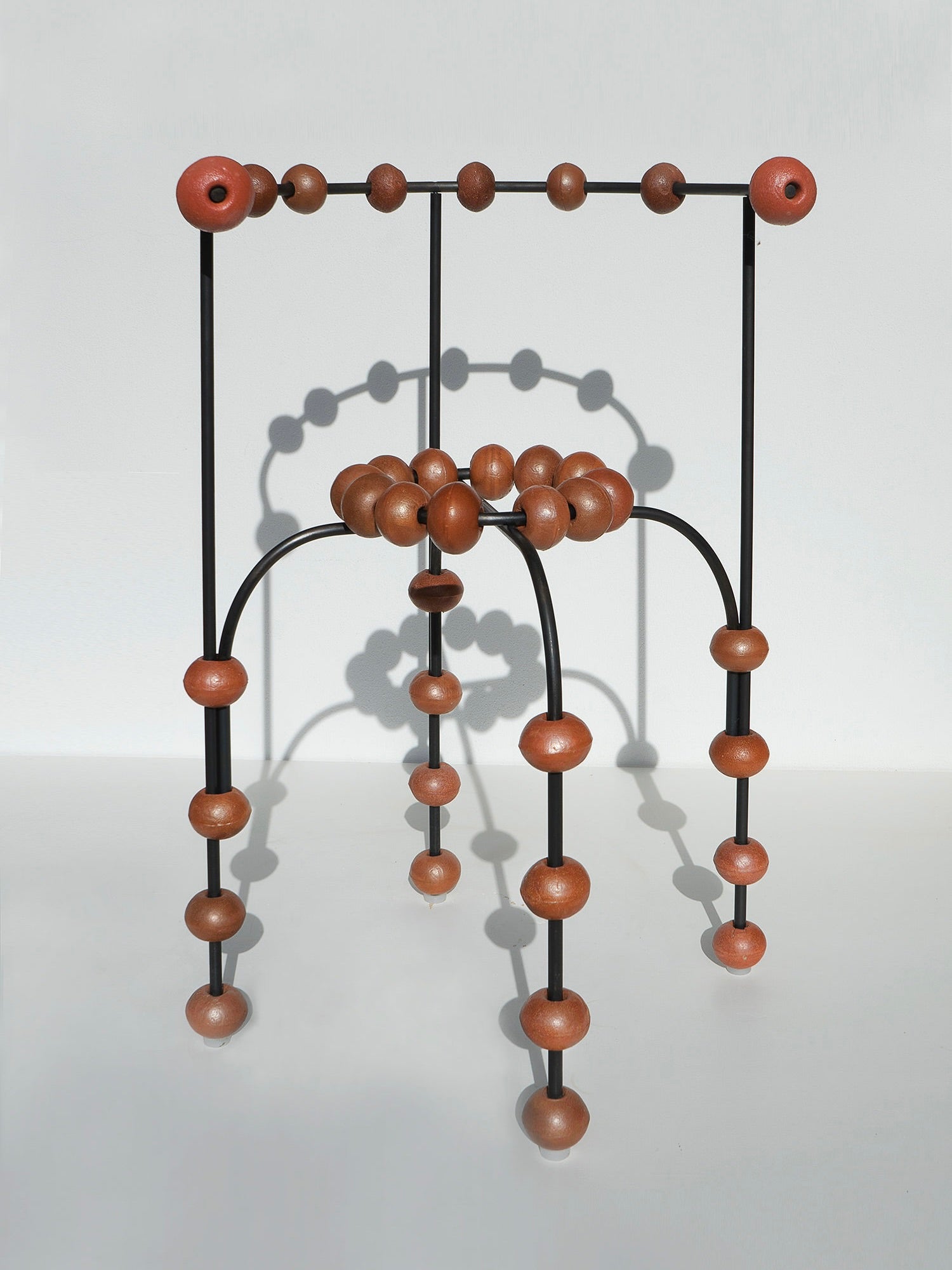 The "Buoys" Chair — side angle showing wooden beads and black frame