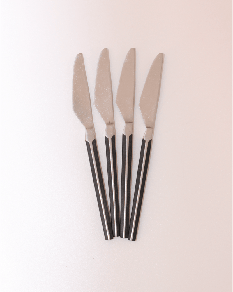 Mid-Century Cutlery — close-up of stainless steel knives with black handles