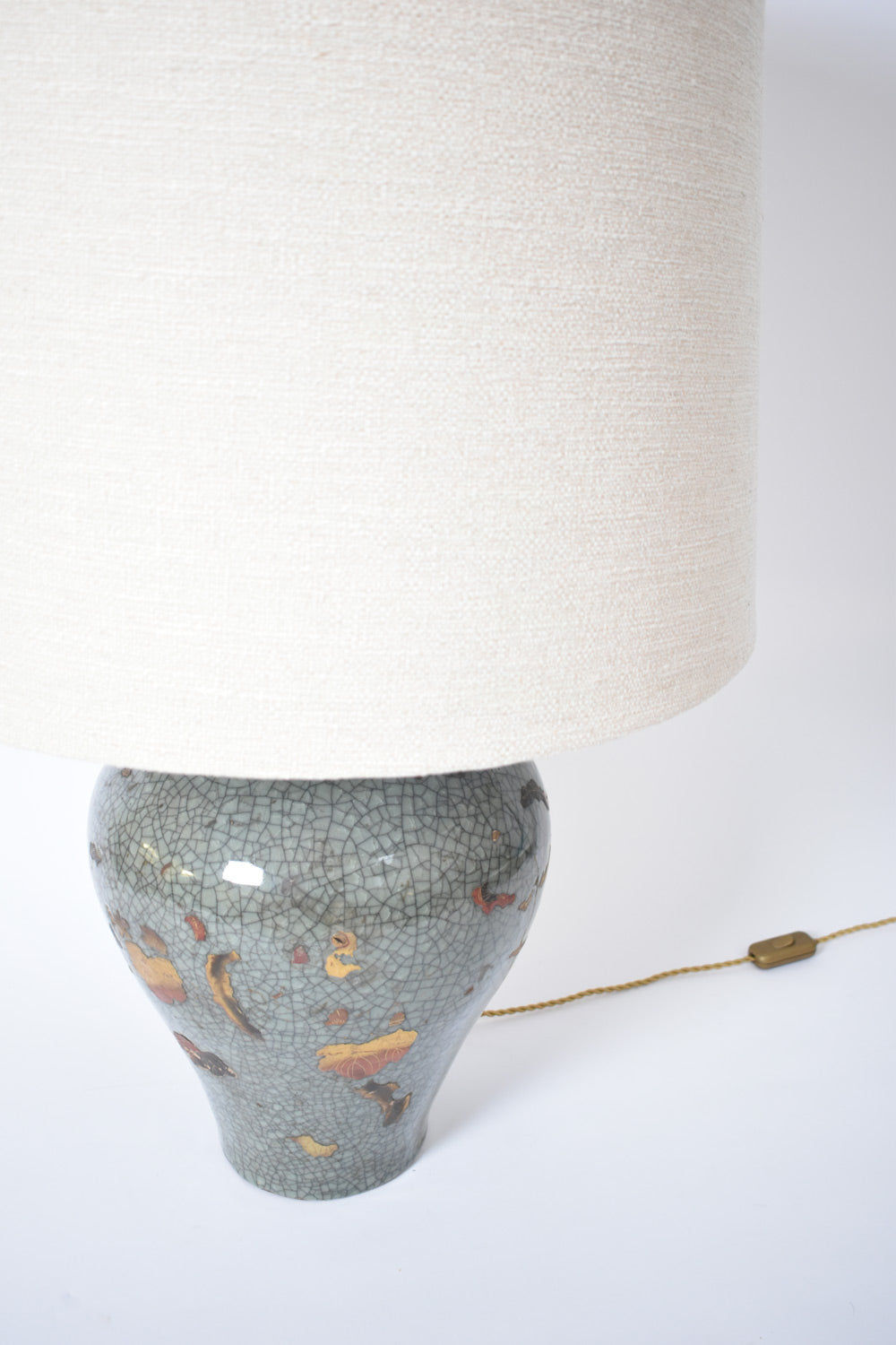 Barracuda Interiors' Chinese Celadon and Gold Lamp, XIXth c., features a crackled floral ceramic base, an off-white fabric shade, and a visible brown inline switch on the cord—drawing inspiration from 19th-century Chinese design.