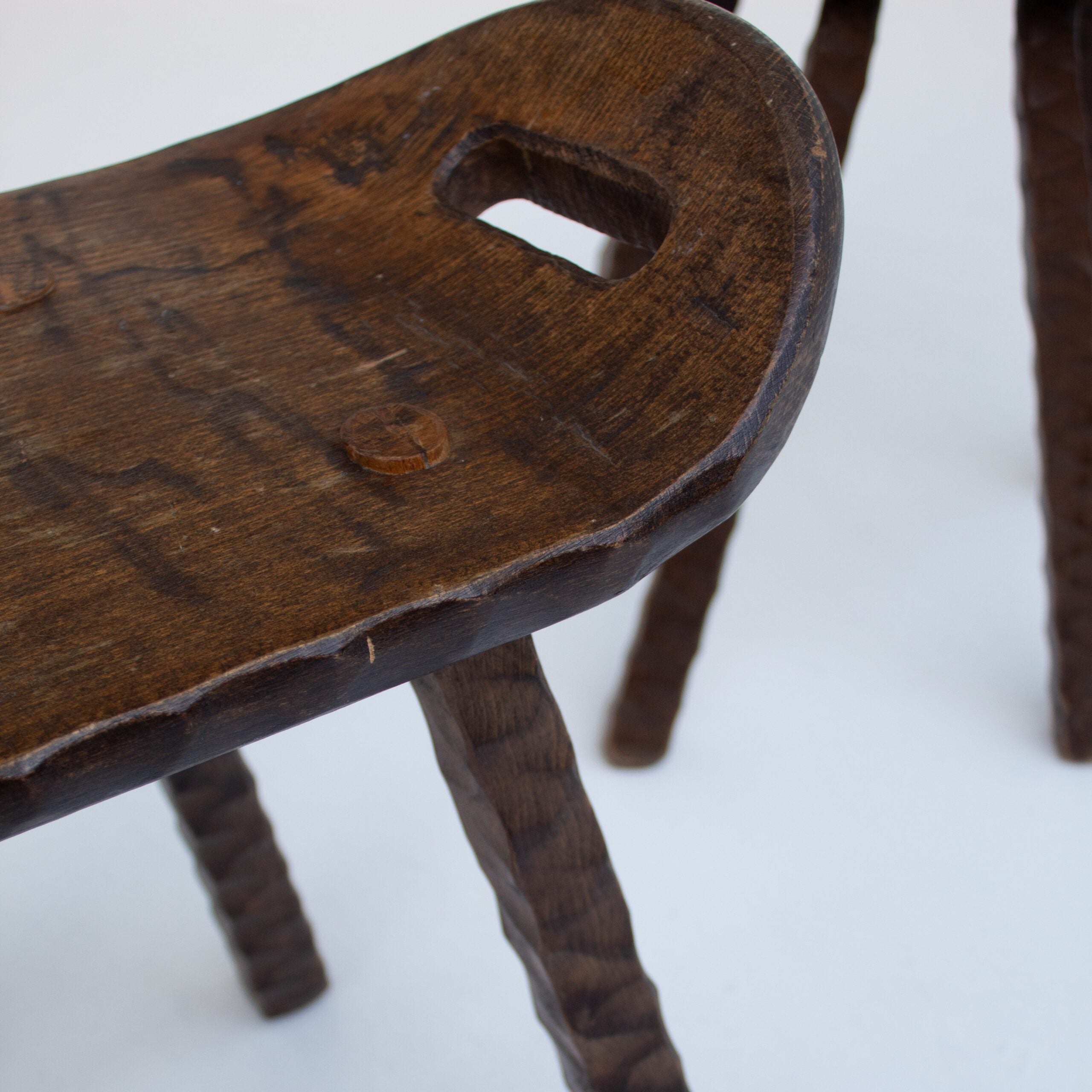 Set of Brutalist stools — close-up of textured dark wood seat