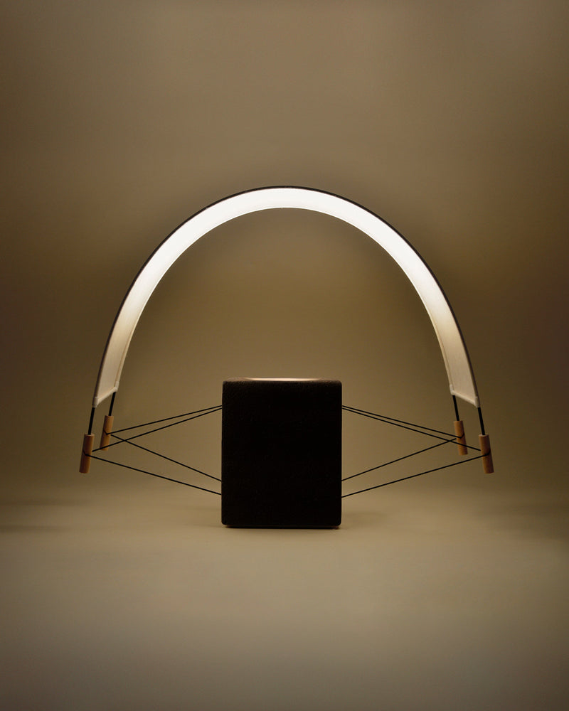 Modern black table lamp with curved LED arch and geometric base