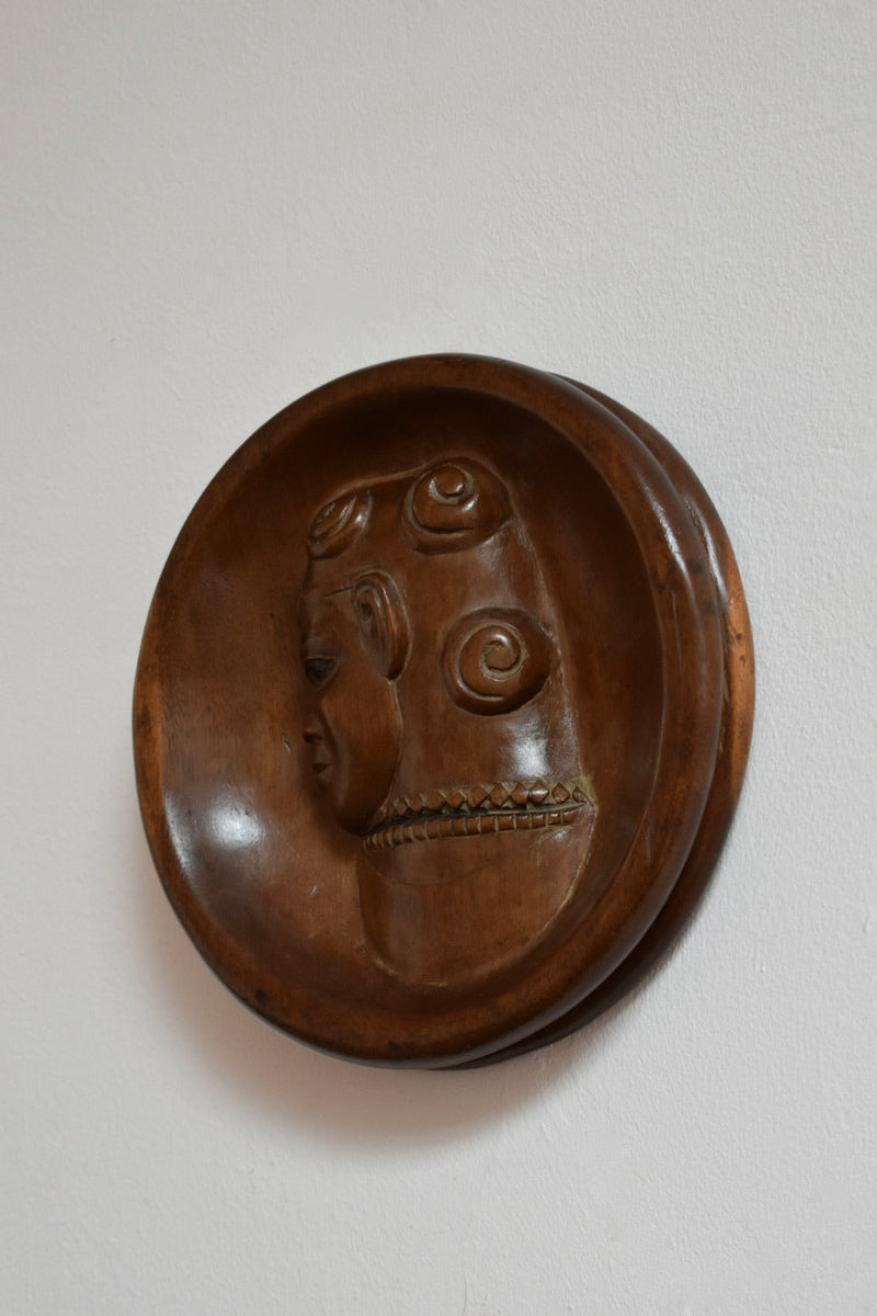 Africanist Low Relief Round Wooden Wall Sculpture — close-up of carved wooden face detail