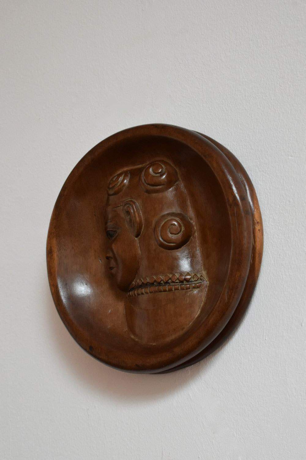 Africanist Low Relief Round Wooden Wall Sculpture — close-up of carved wooden face detail