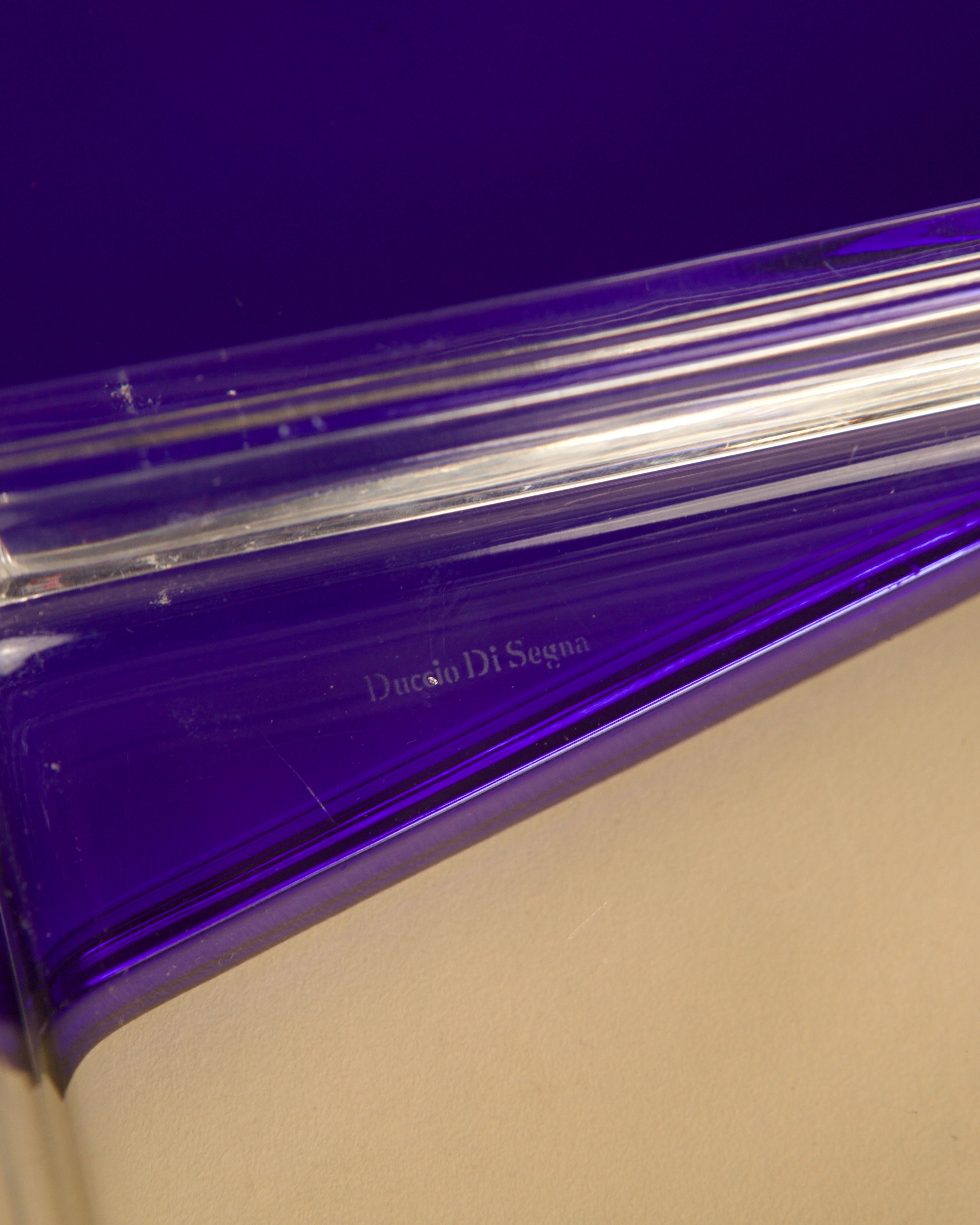 A close-up of Treaptyque’s Italian Box in transparent and blue crystal by Duccio Di Segna, 1980s, shows the engraved logo at center against a neutral beige background, reflecting classic Italian design.