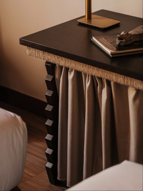 Escritorio Desk — close-up of dark wood surface with fabric draping