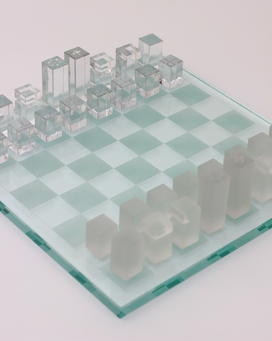 Ajedrez Minimalista — side angle of glass chess pieces on board