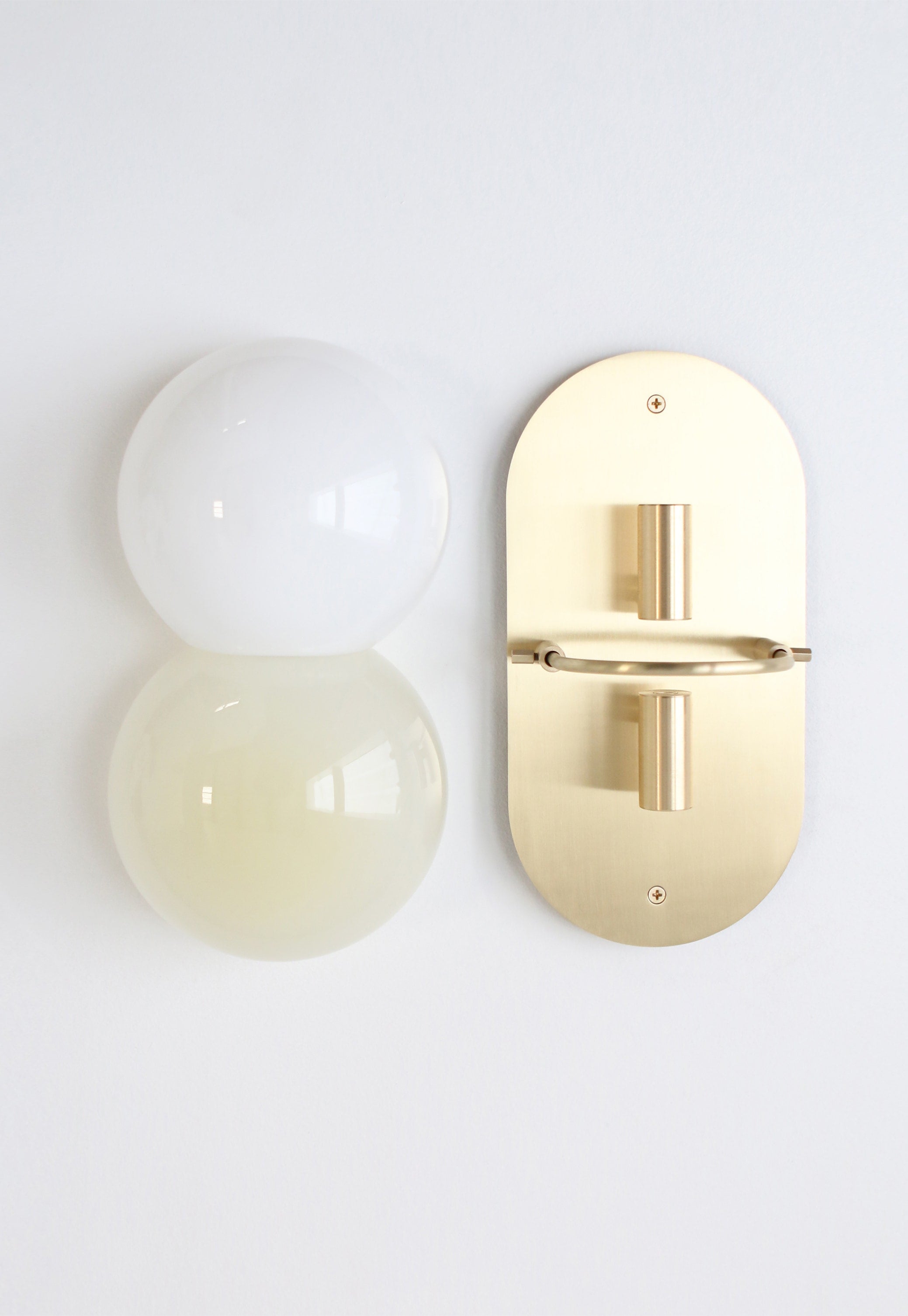 SkLO Twin 1.0 Sconce - Light beige/white glass, Brushed Brass finish — lifestyle setting