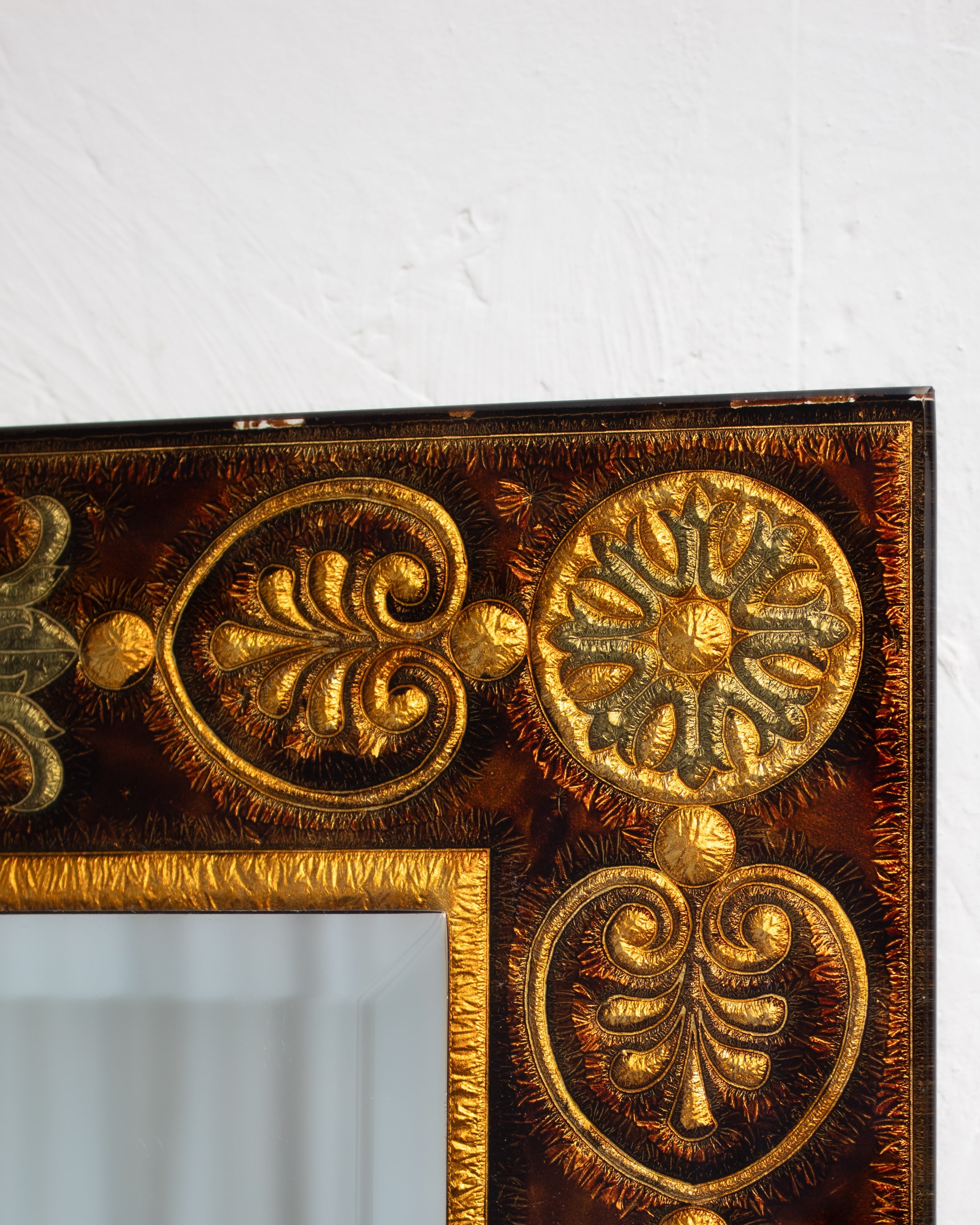 Ornate golden frame detail of antique wall mirror with baroque scrollwork