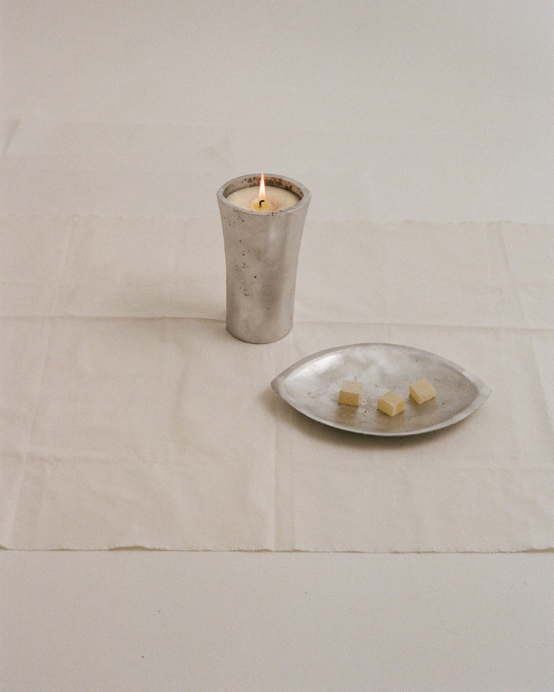 Aluminium Candle Sculpture — close-up of candle on white fabric