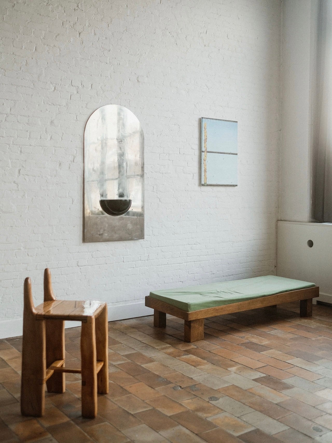 The Mirror of Simple Souls (Large) - Contemporary Mirror in Steel — mounted on white brick wall in minimalist setting
