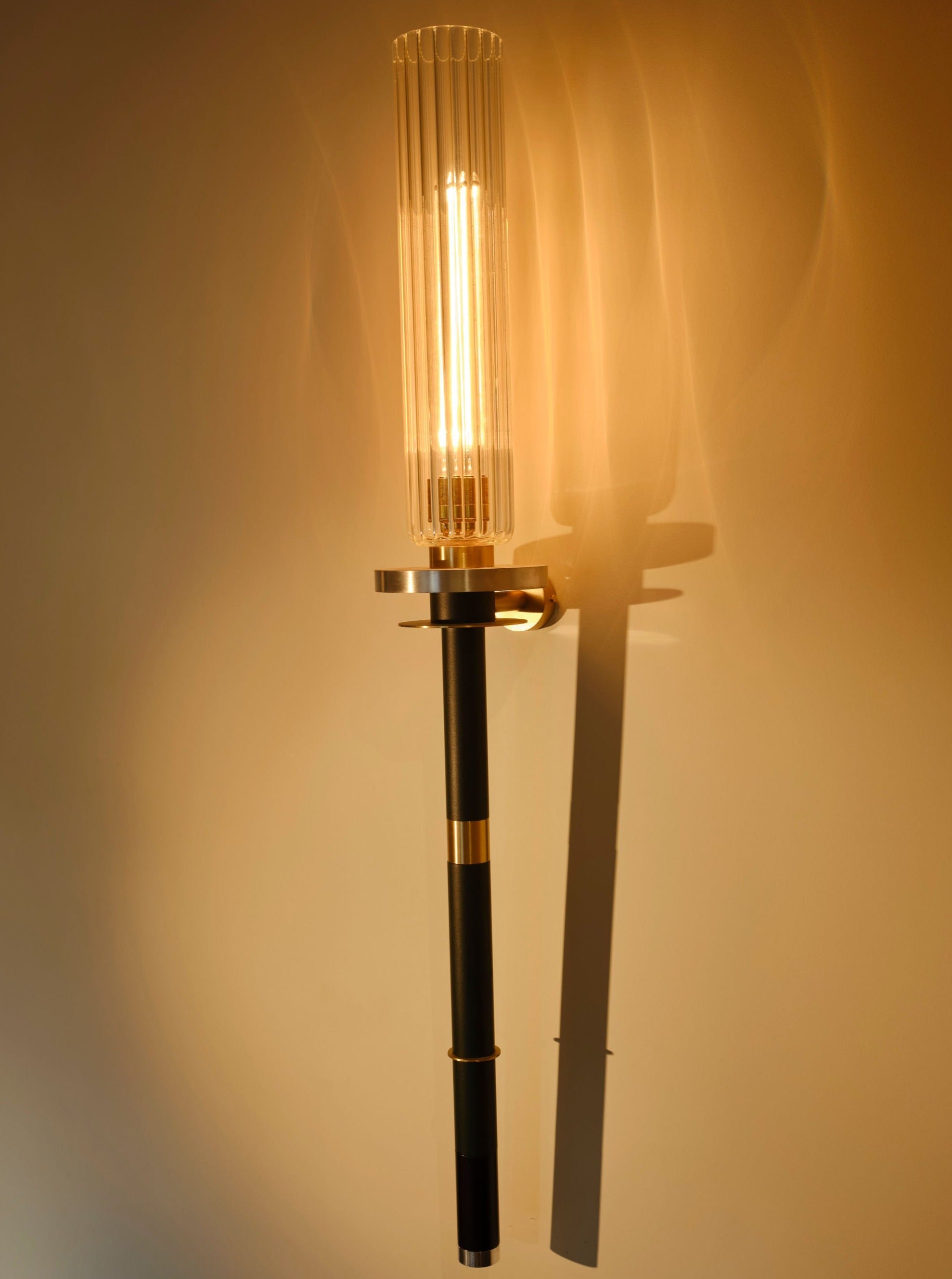 Torca Wall Light — side angle showing glass shade and black metal arm