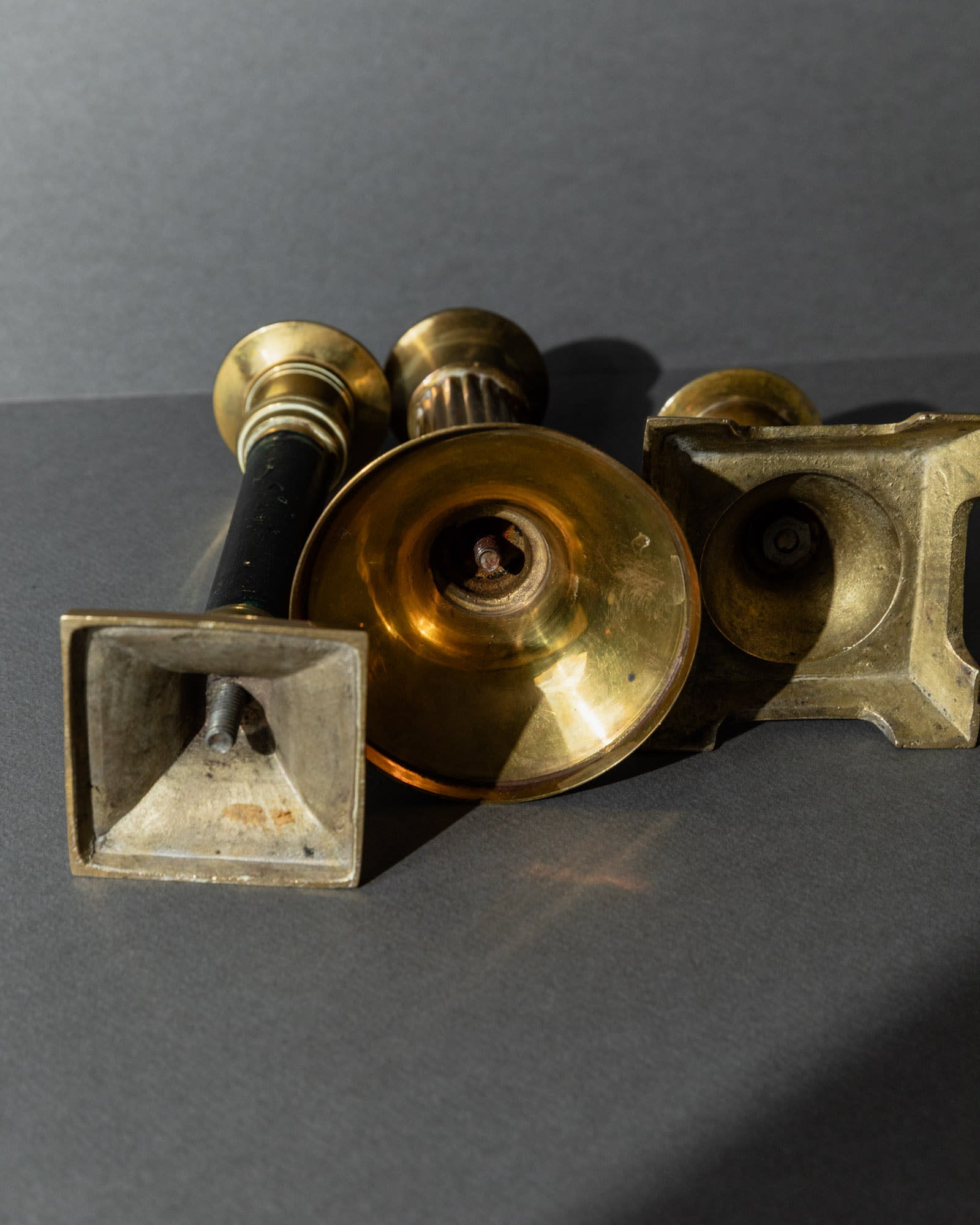 Vintage 1940s Brass Candleholders Set of 3, Mixed Shapes, Classic Antique Design — close-up of brass surfaces with varied sha