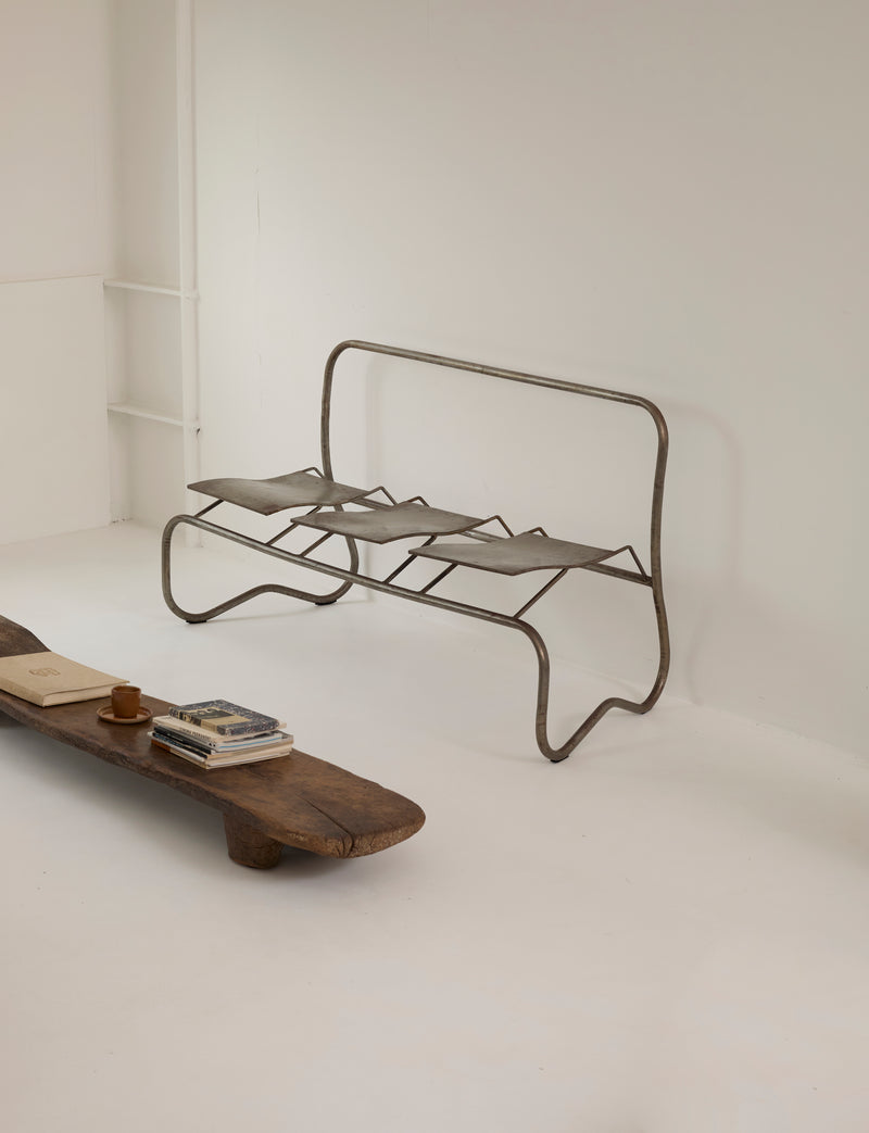 Unique Signed Artist Bench / Settee in Metal — side view of metal frame in minimalist setting