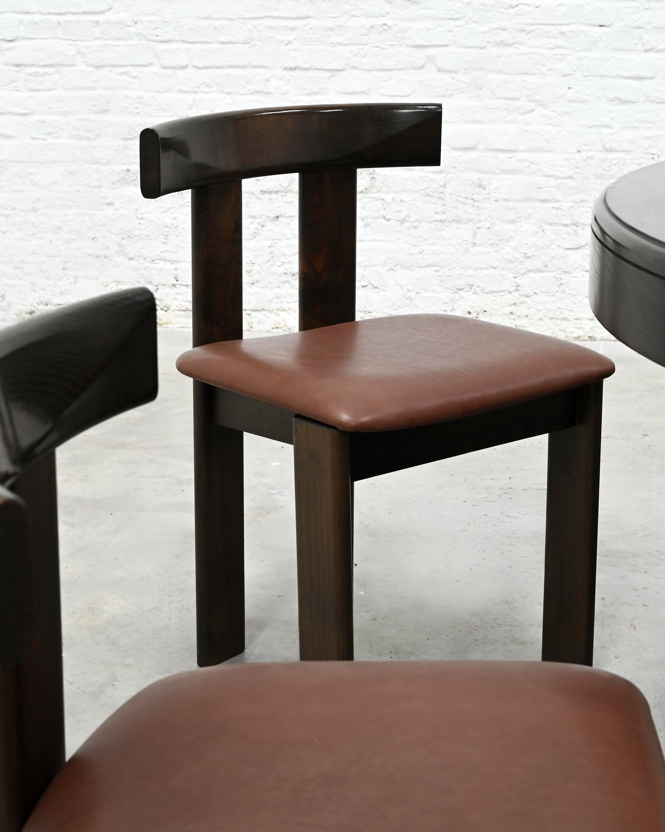 Close-up detail of leather dining chair with dark wood frame