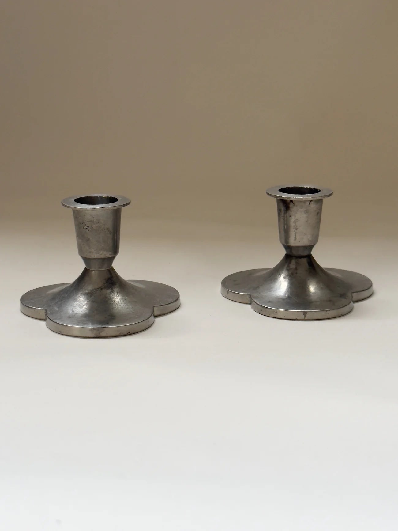 Pair of Pewter Candlesticks by Just Andersen — front view on neutral background