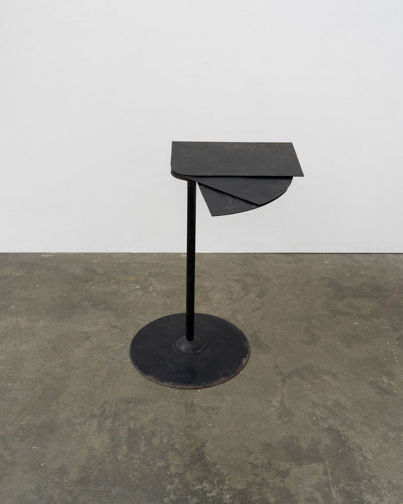 Minimalist black metal side table with asymmetrical geometric top