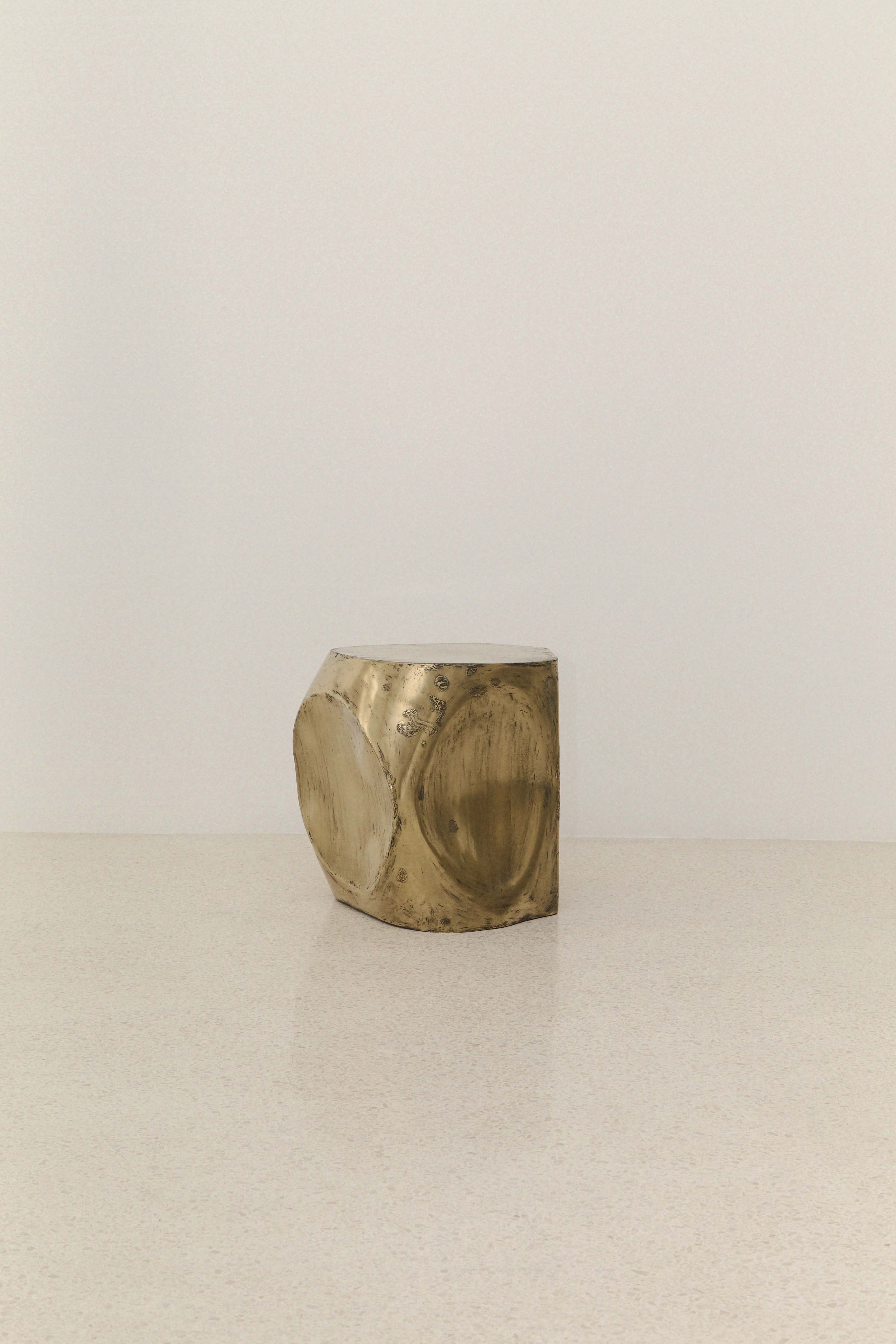 ROCHER SMALL TABLE IN POLISHED BRASS RESIN — angled view on light surface