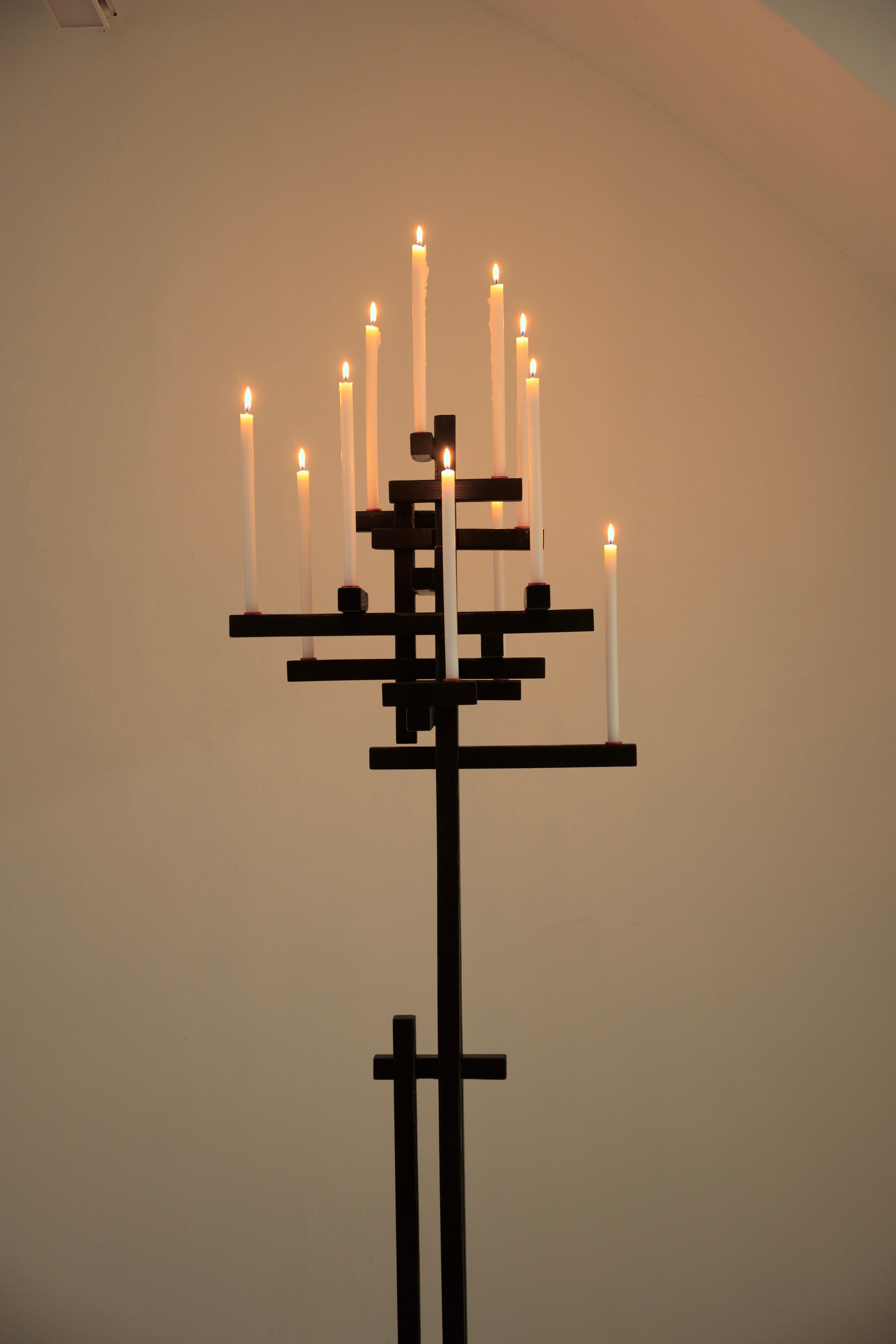 TETRIS CANDELABRUM — close-up of black metal structure with lit candles