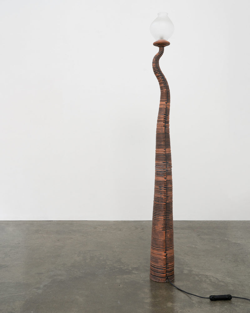Tall curved terracotta floor lamp with ribbed texture by Tom Bogle