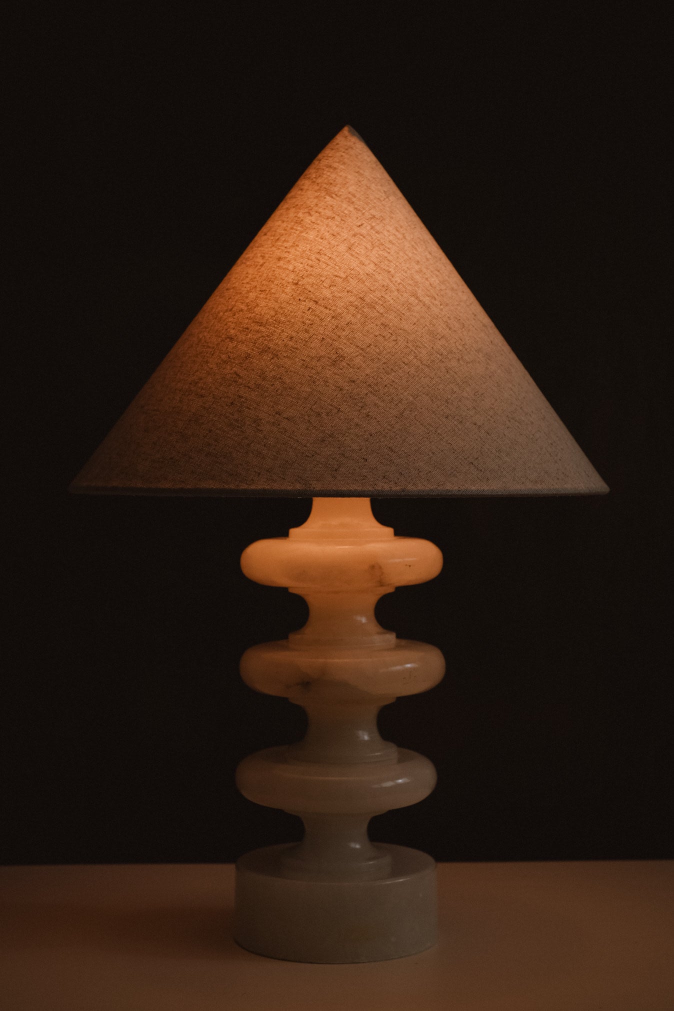Sculptural Alabaster Table Lamp — lit lamp against dark background