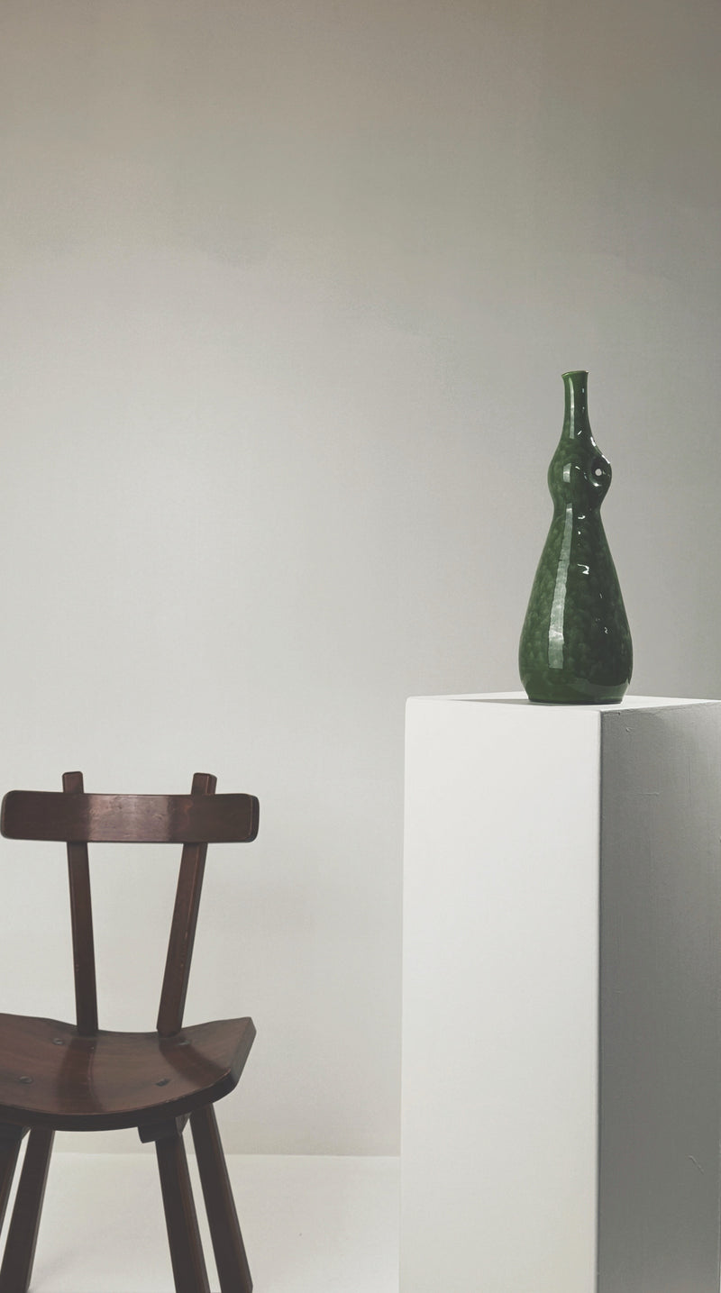 Green ceramic pinched bottle by Accolay Potters displayed on white pedestal