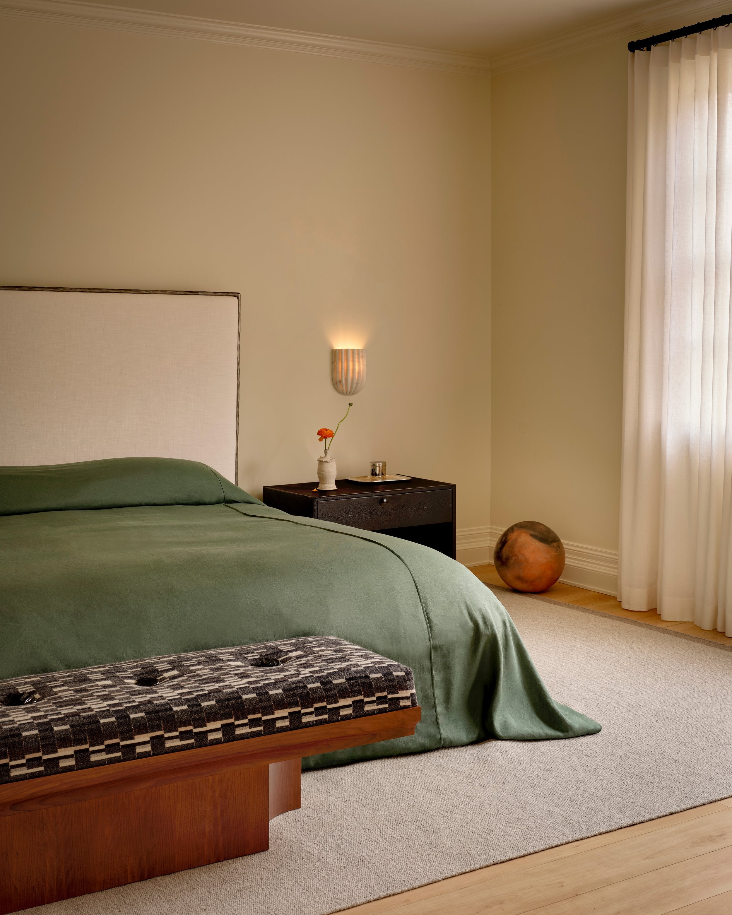 The Naos Bench — side view with patterned fabric in bedroom setting