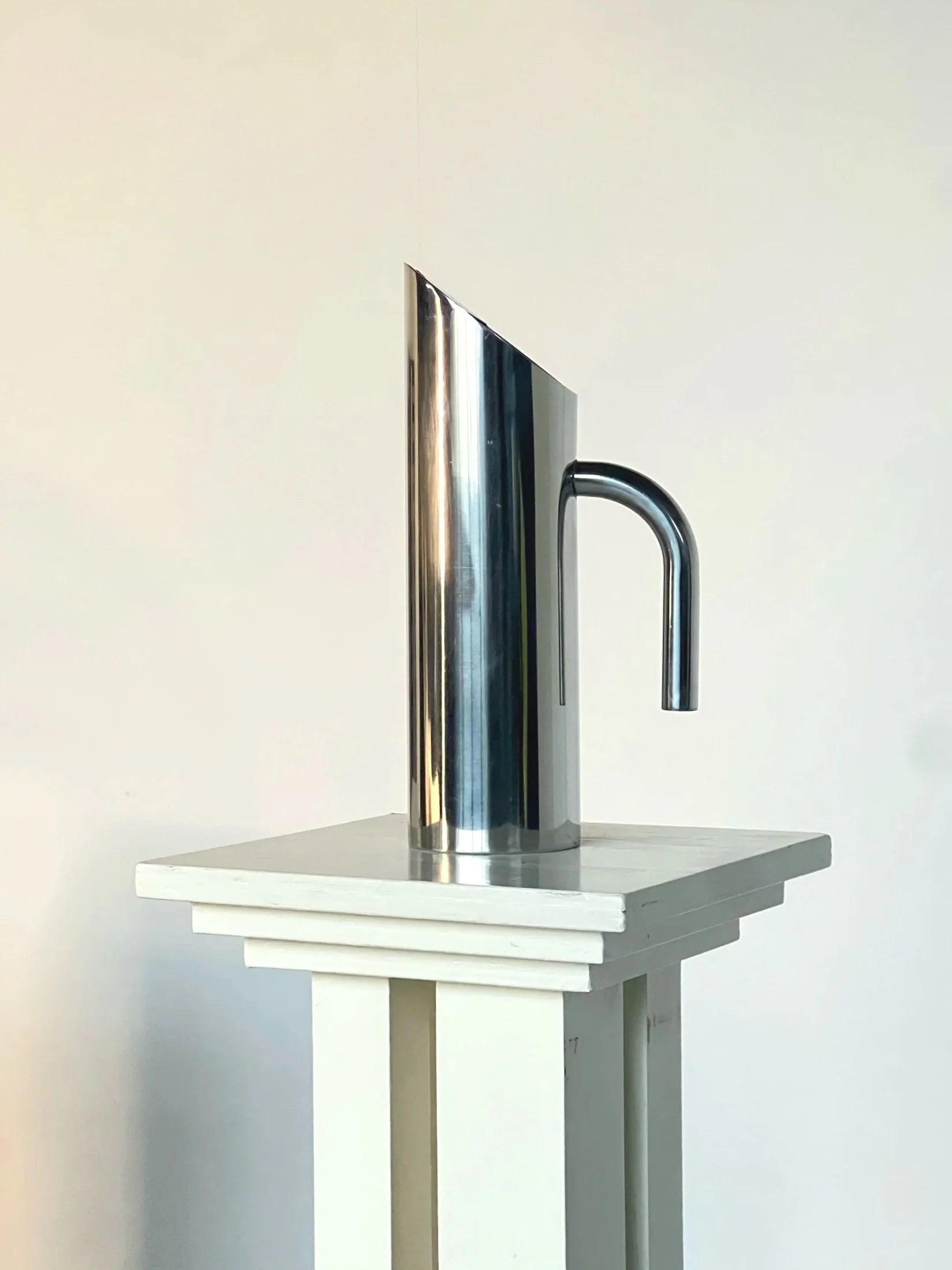 Sculptural Polished Water Jug — angled view on white pedestal