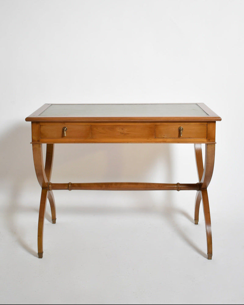 The Barracuda Interiors Directoire style curule console table, 1970s, features a wooden frame, glass top, curved legs, and two front drawers with metal handles, shown against a plain white background.