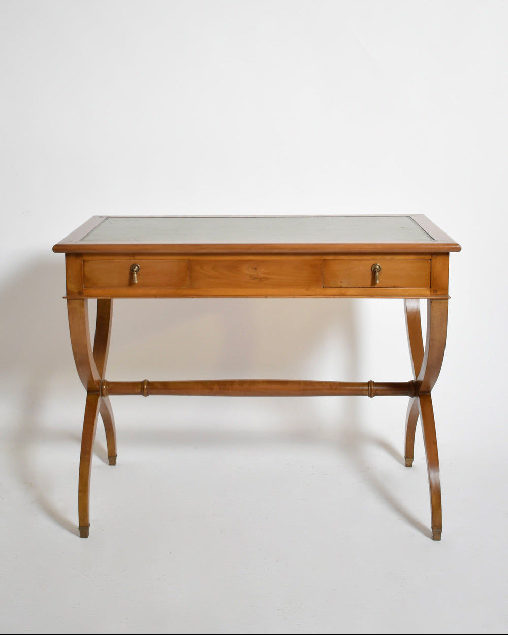 The Barracuda Interiors Directoire style curule console table, 1970s, features a wooden frame, glass top, curved legs, and two front drawers with metal handles, shown against a plain white background.