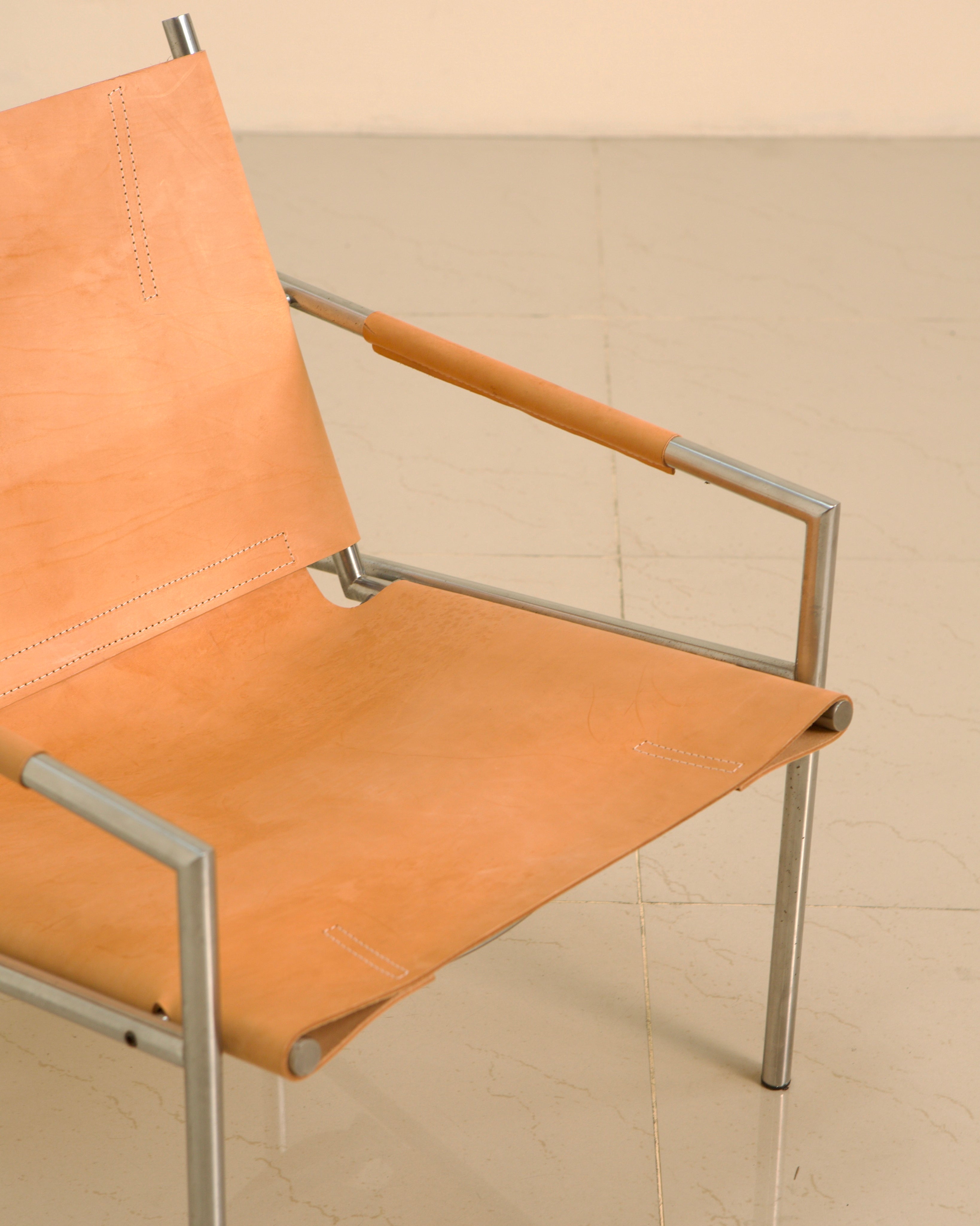 Orange leather SZ02 armchair detail showing stitched seams and steel frame