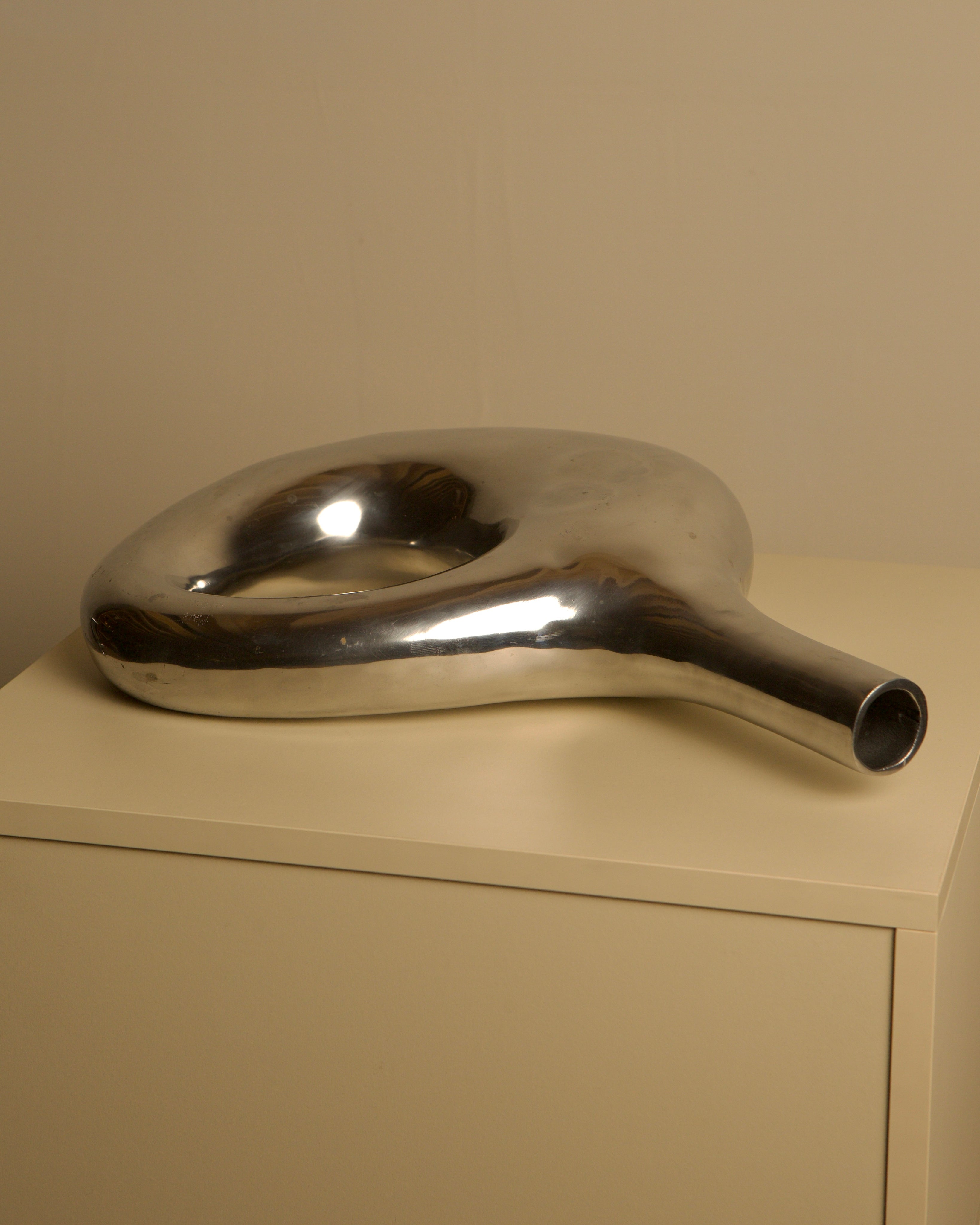 Large Italian cast aluminum vase from the 80s — angled view on neutral surface