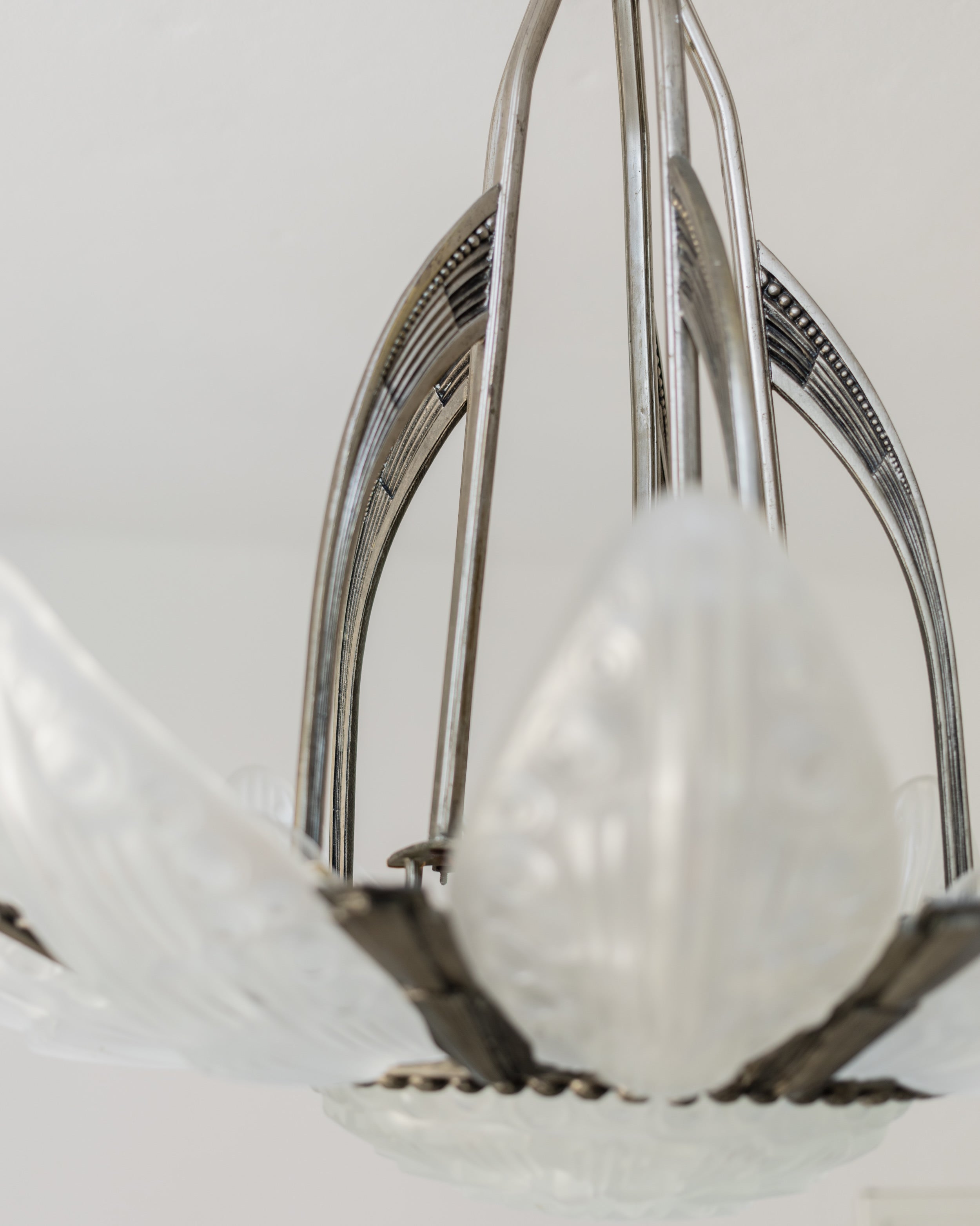 Close-up detail of Art Deco chandelier's curved metal frame and wiring