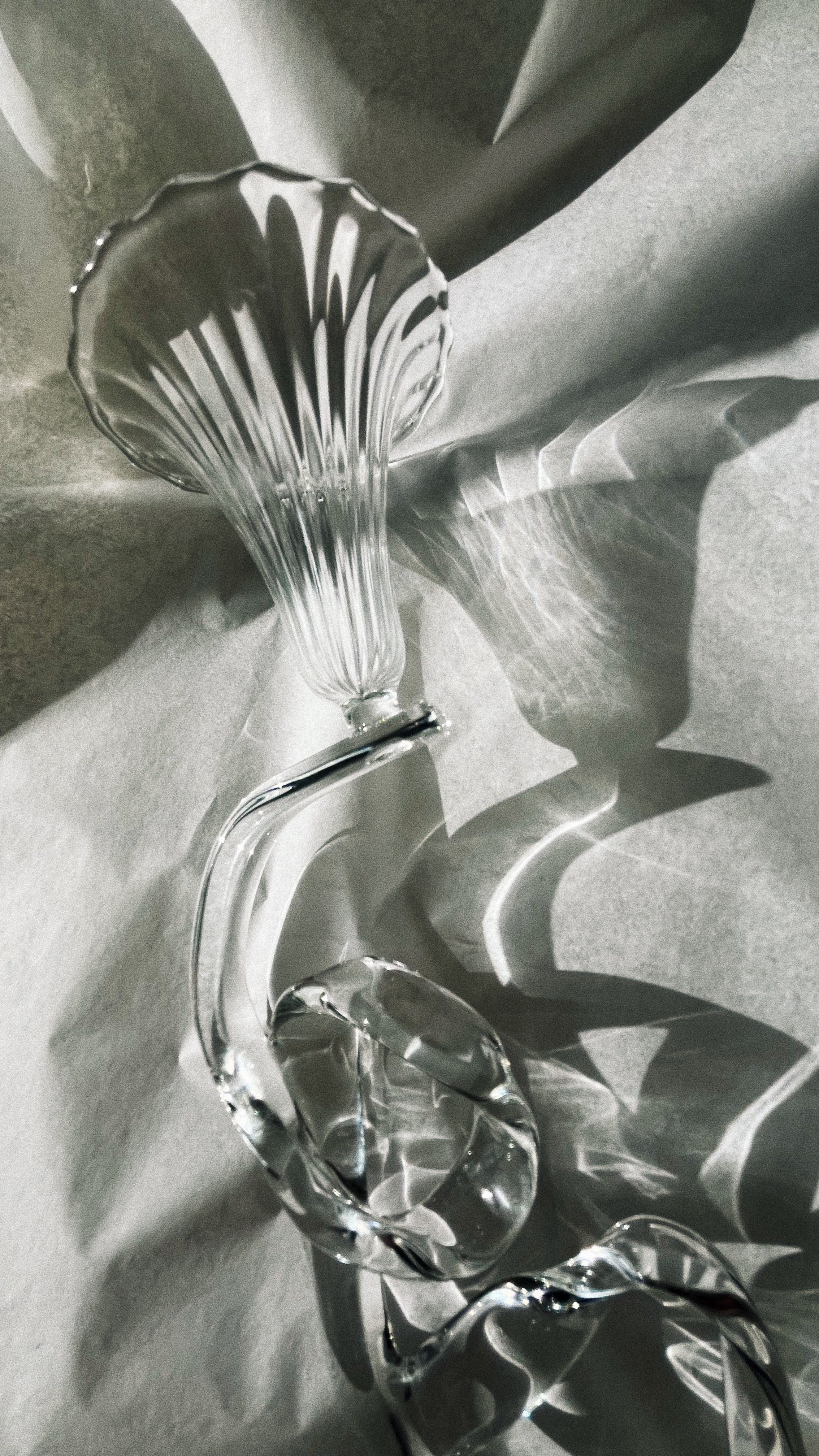 Glass ribbon candleholder with flowing curves and floral arrangement