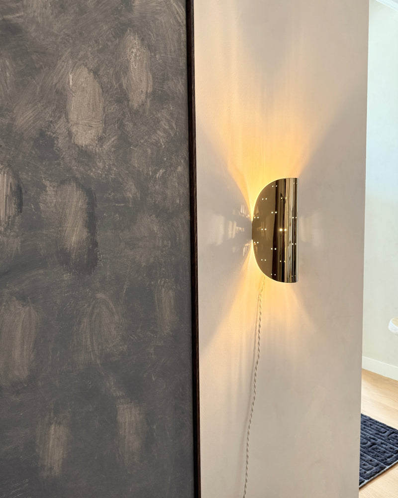 Giselle Wall Lamp - Polished Steel — close-up of polished steel surface on wall