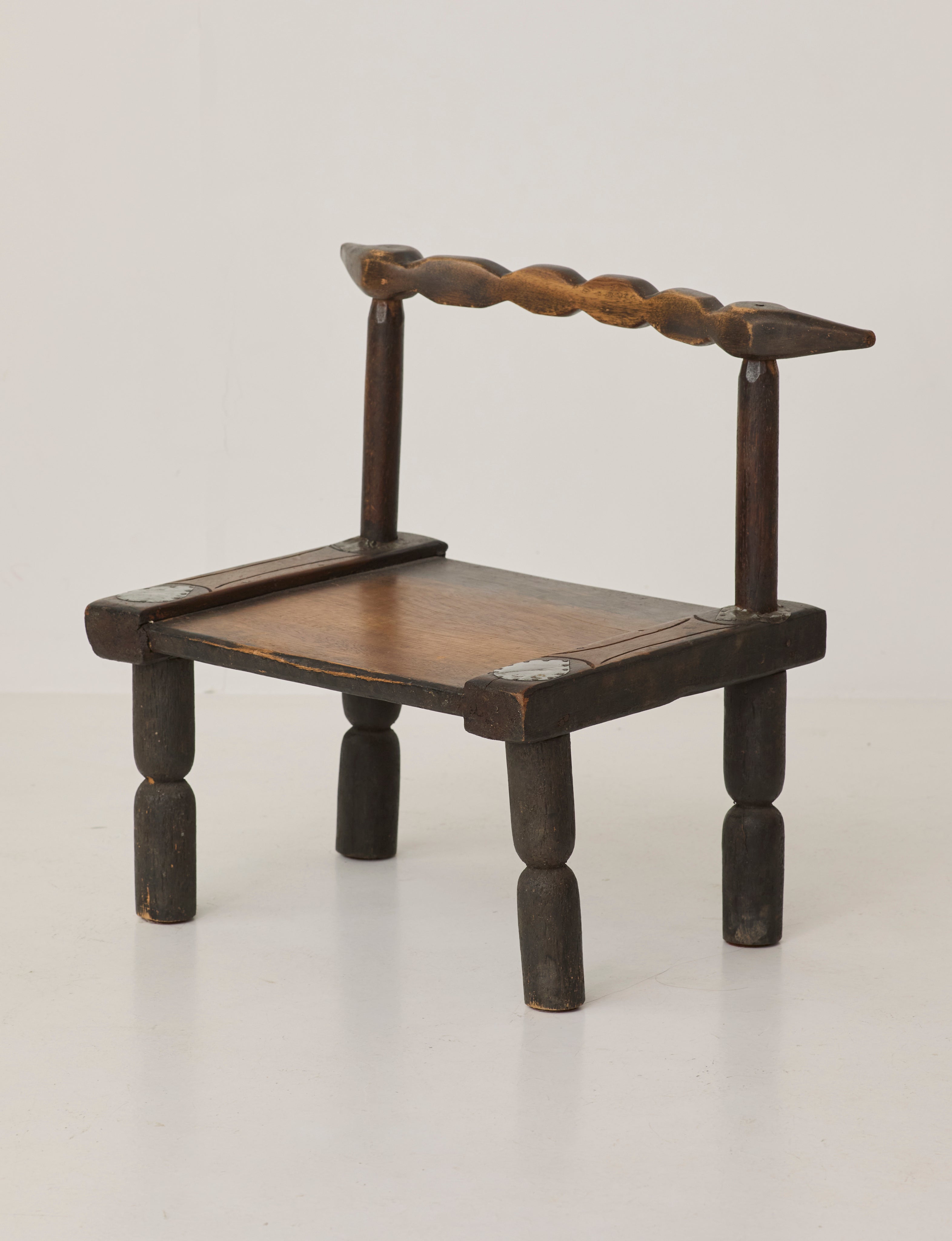 Small artisanal vintage West African chair "Baoulé" in solid wood C. 1960 — side angle