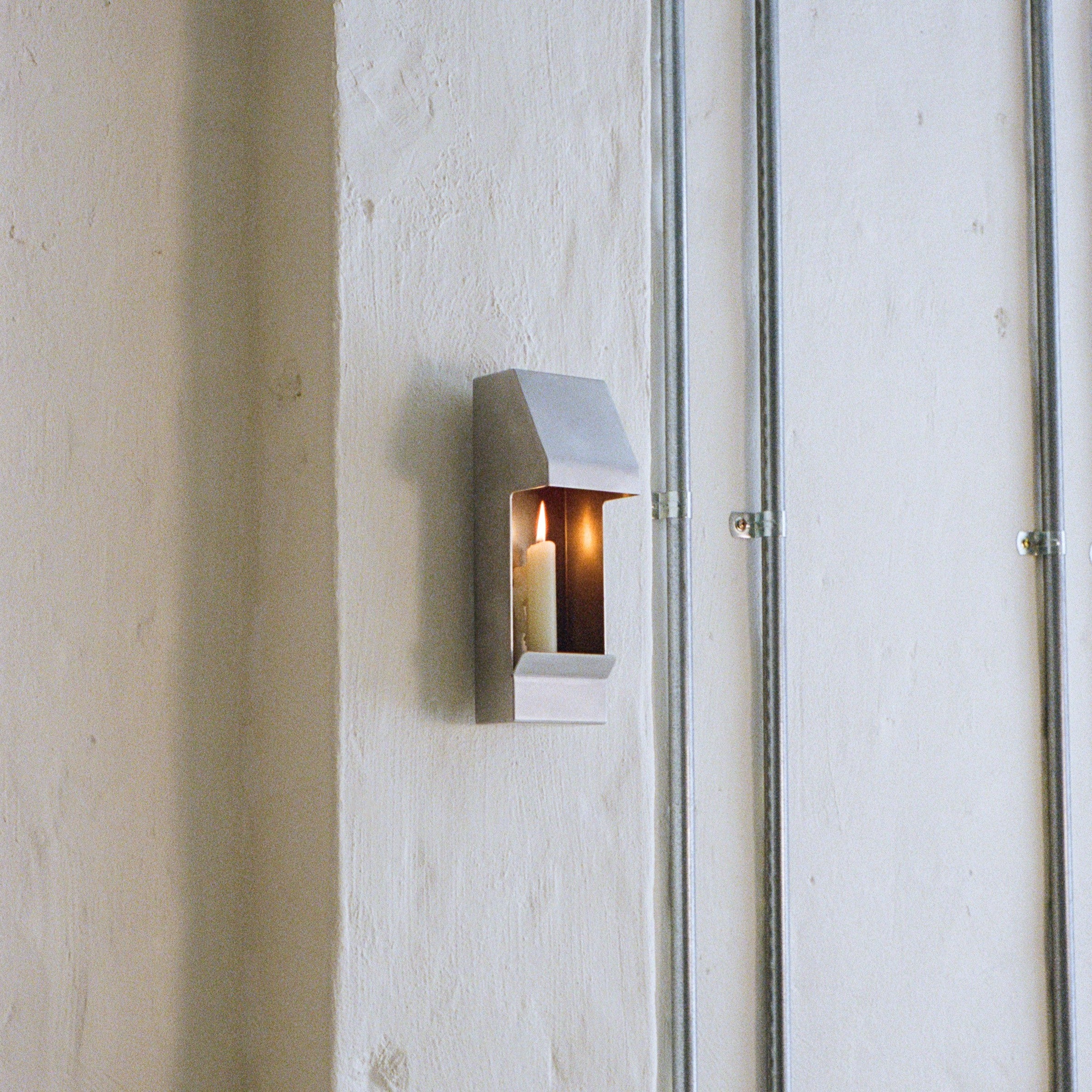 Egress Sconce Candle Holder — side view against textured wall